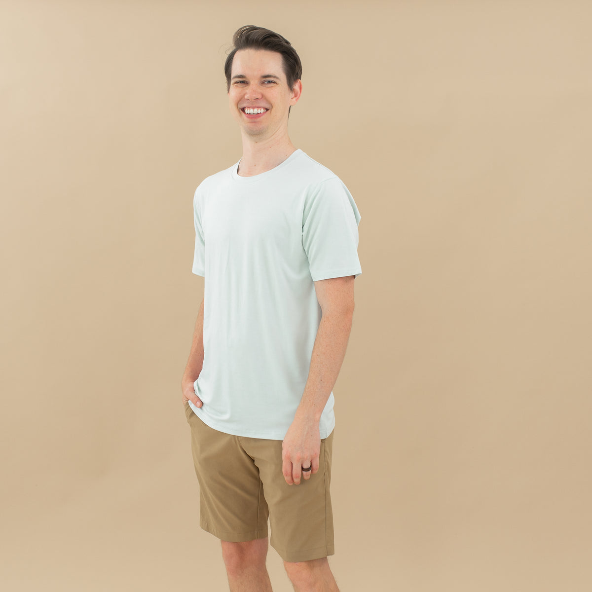 Male model wearing the Men's Crew Neck Tee in Dew paired with tan shorts