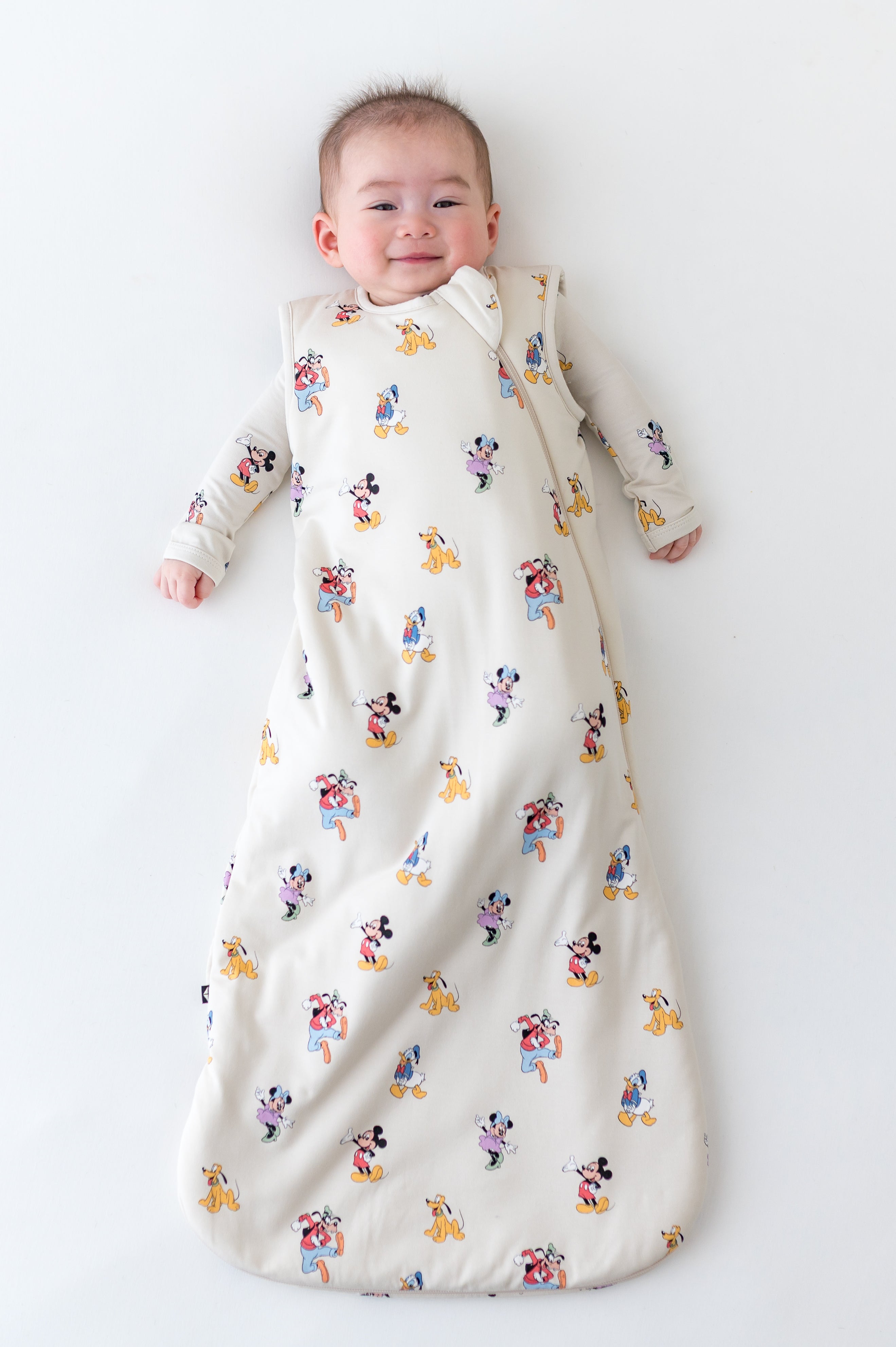 Baby in a sleep sack with mickey and friends pattern
