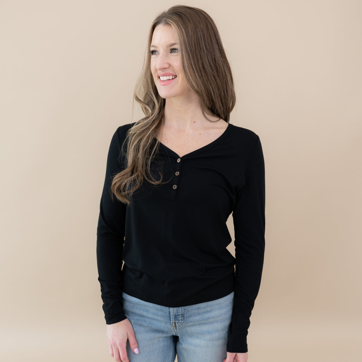 Woman wearing Kyte Baby Women's Bamboo Long Sleeve Henley Tee in Midnight black
