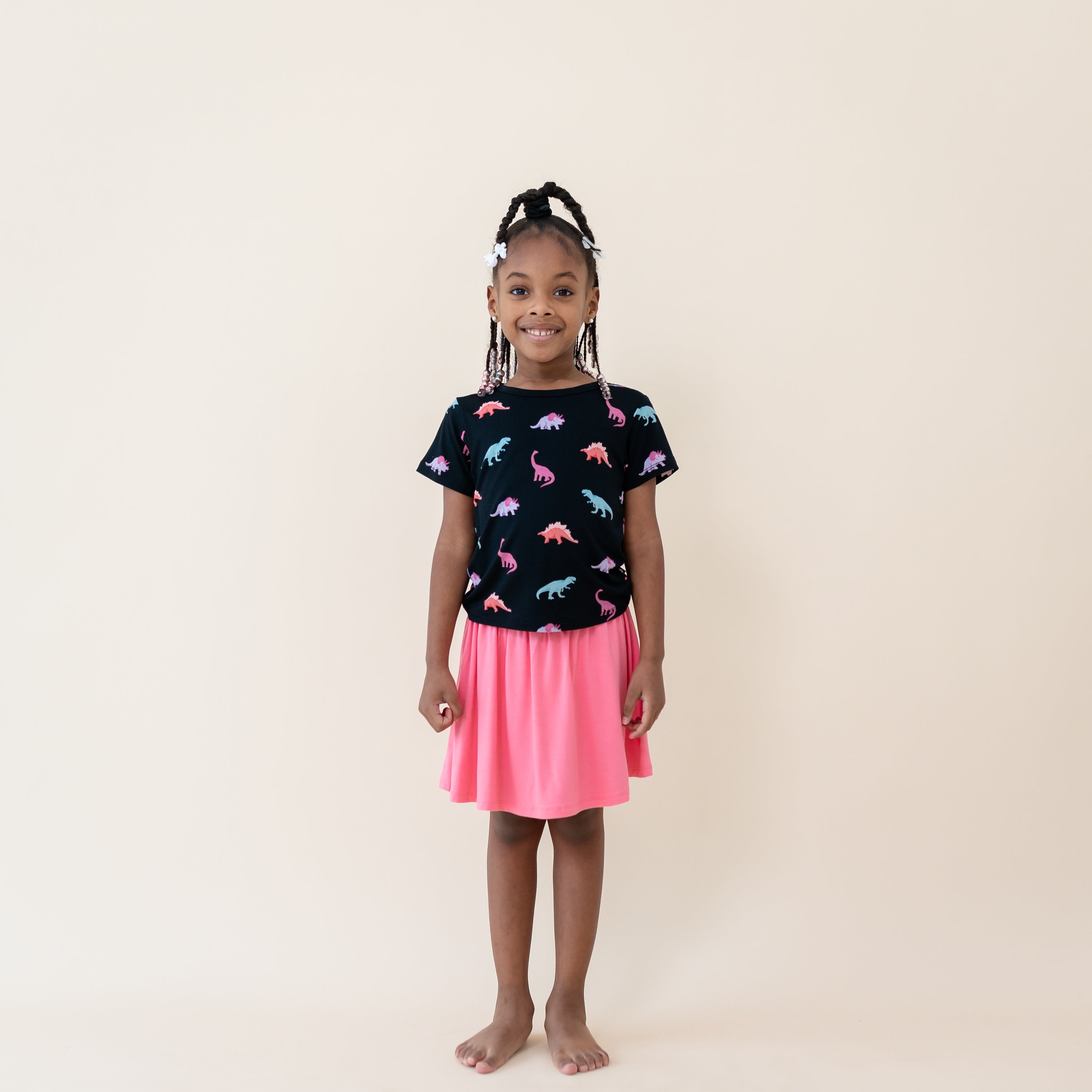 Girl modeling the Toddler Basic Tee in Midnight Roar paired with Guava Skort