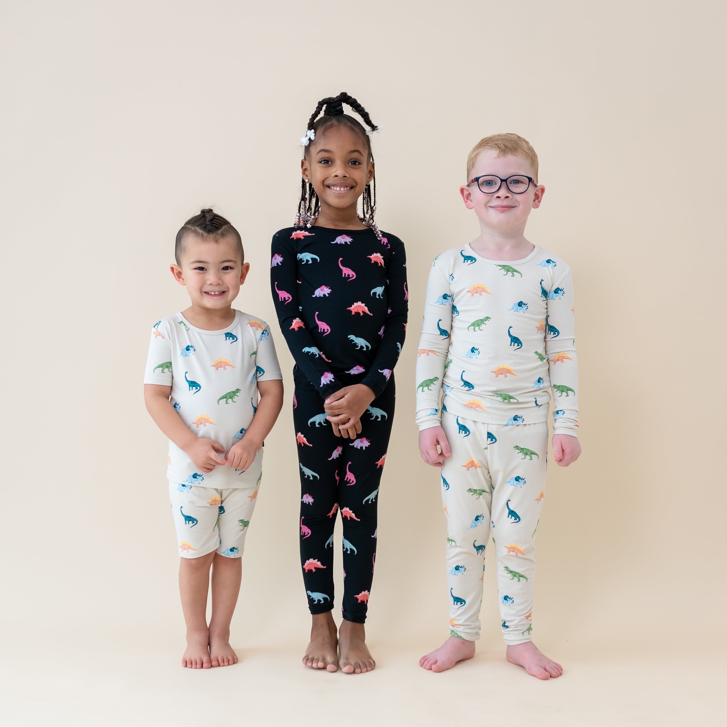 Kids wearing Ecru and Midnight Roar dinosaur pajamas