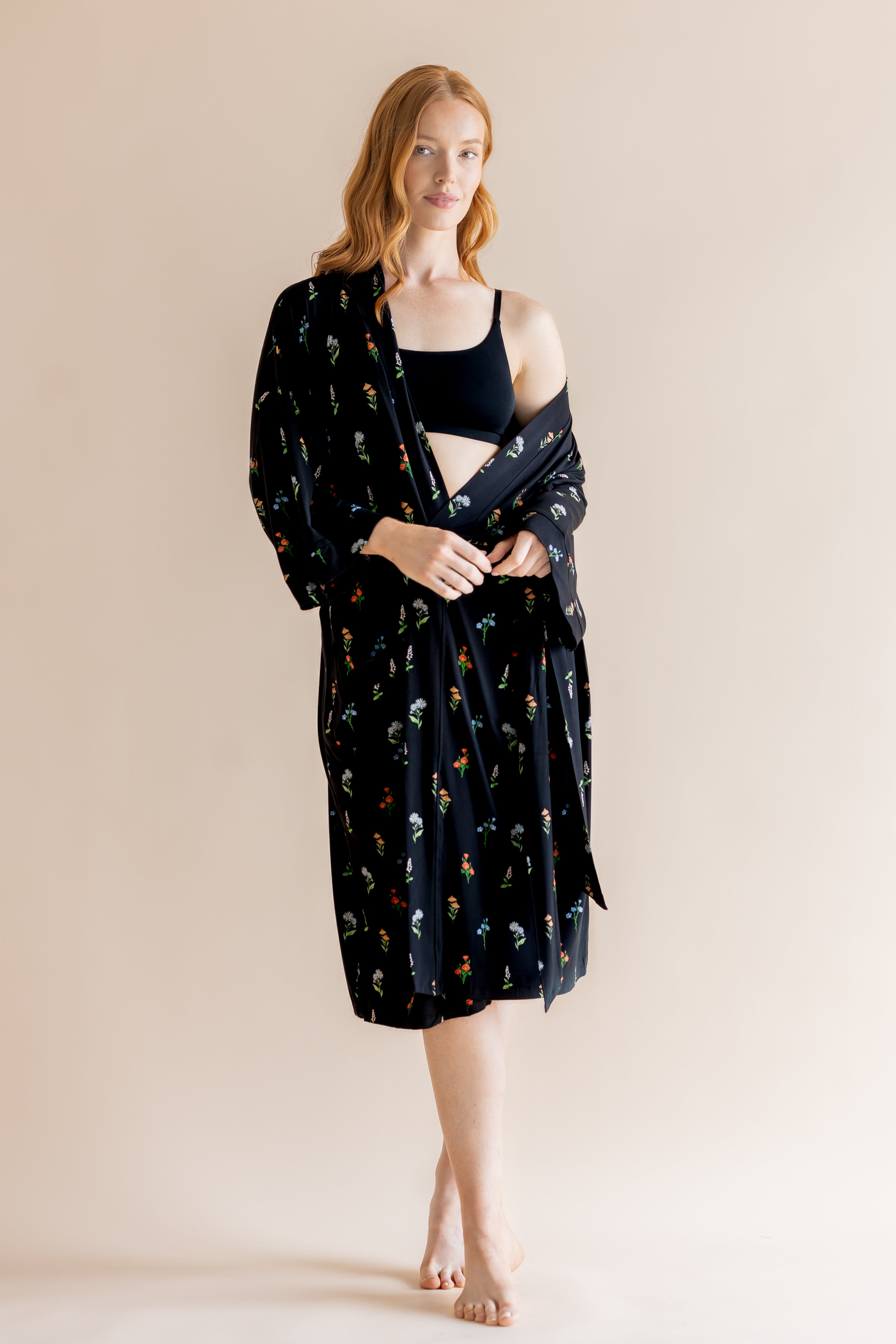 Model wearing Women’s Kimono Robe in Midnight Wildflower print and black bra on a beige background