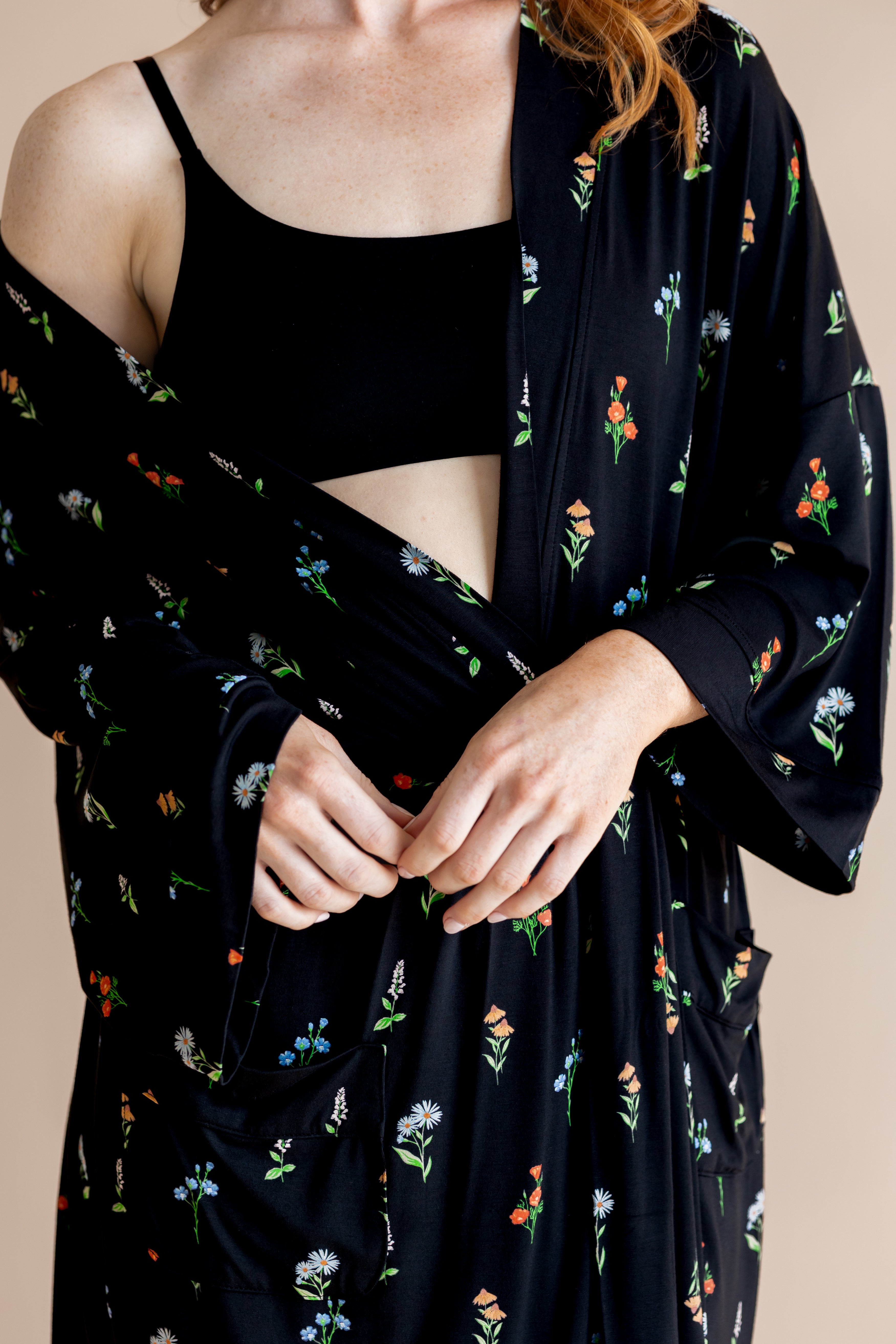 Model wearing Women’s Kimono Robe in Midnight Wildflower print and black bra on a beige background