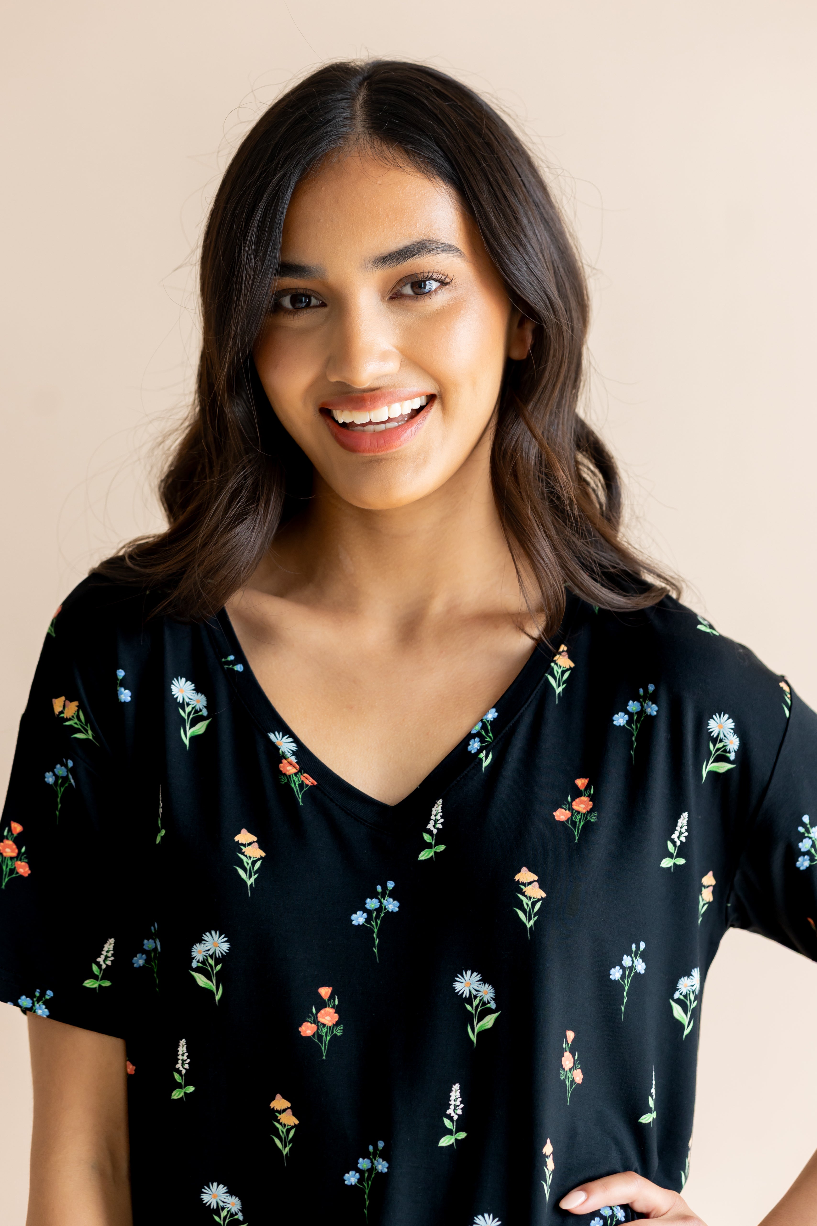 Model smiling in Women's Relaxed Fit V-Neck in Midnight Wildflower print on a beige background