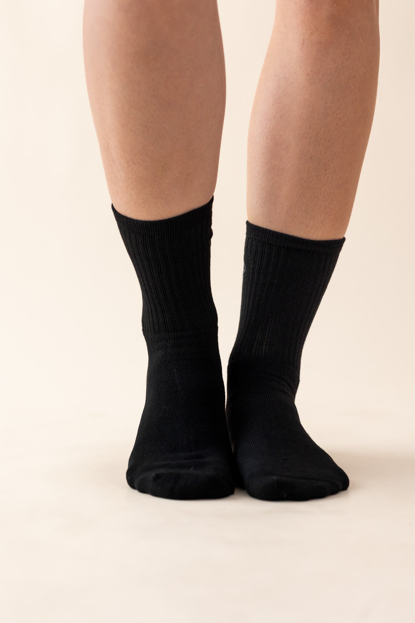 The front of the Adult Crew Socks in Midnight shown on the feet of a model
