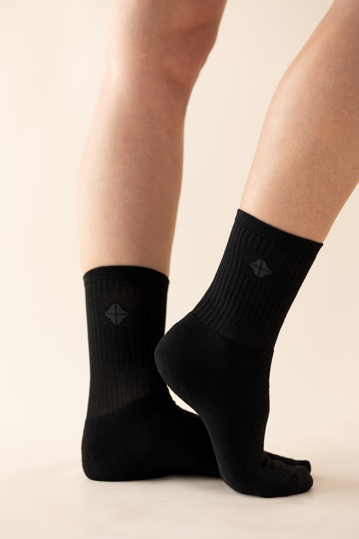 Adult Crew Socks in Midnight with the logo visible shown on models feet