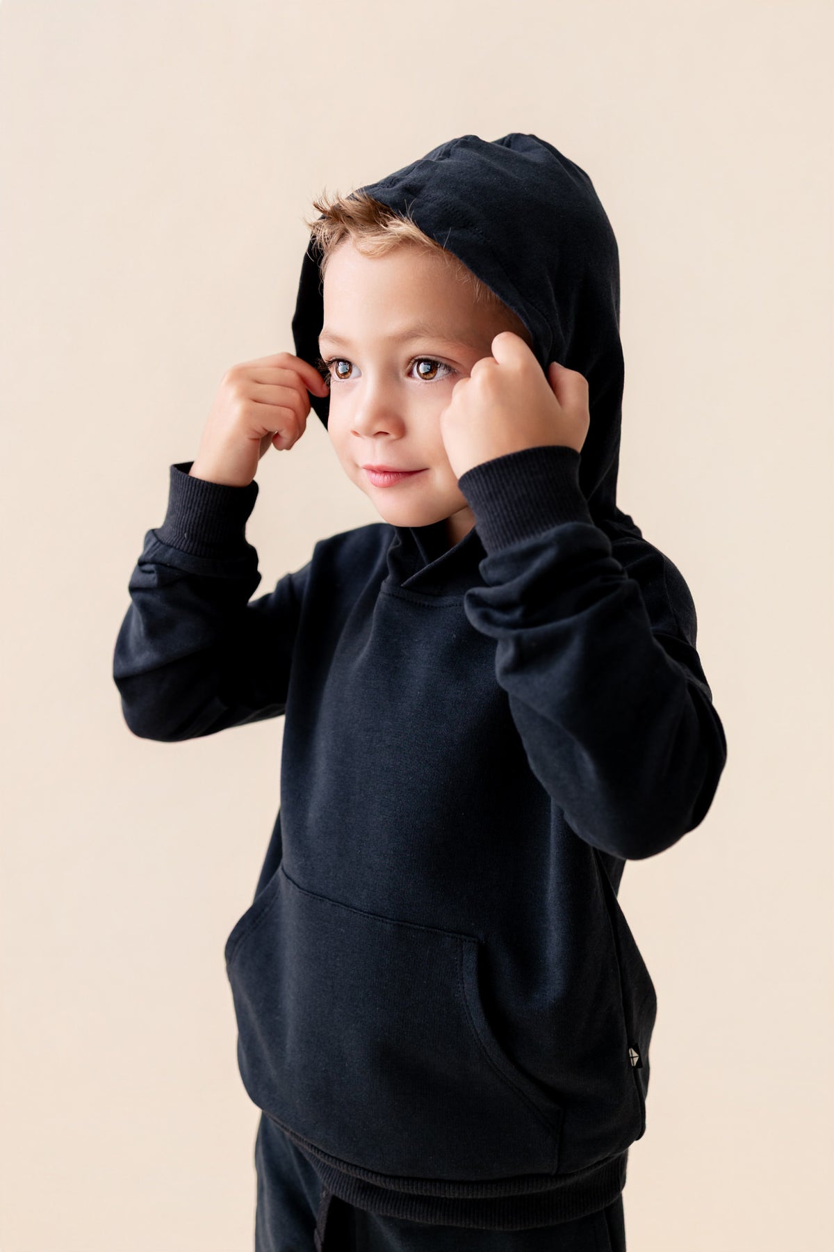 Boy wearing Hoodie in Midnight color on a beige background