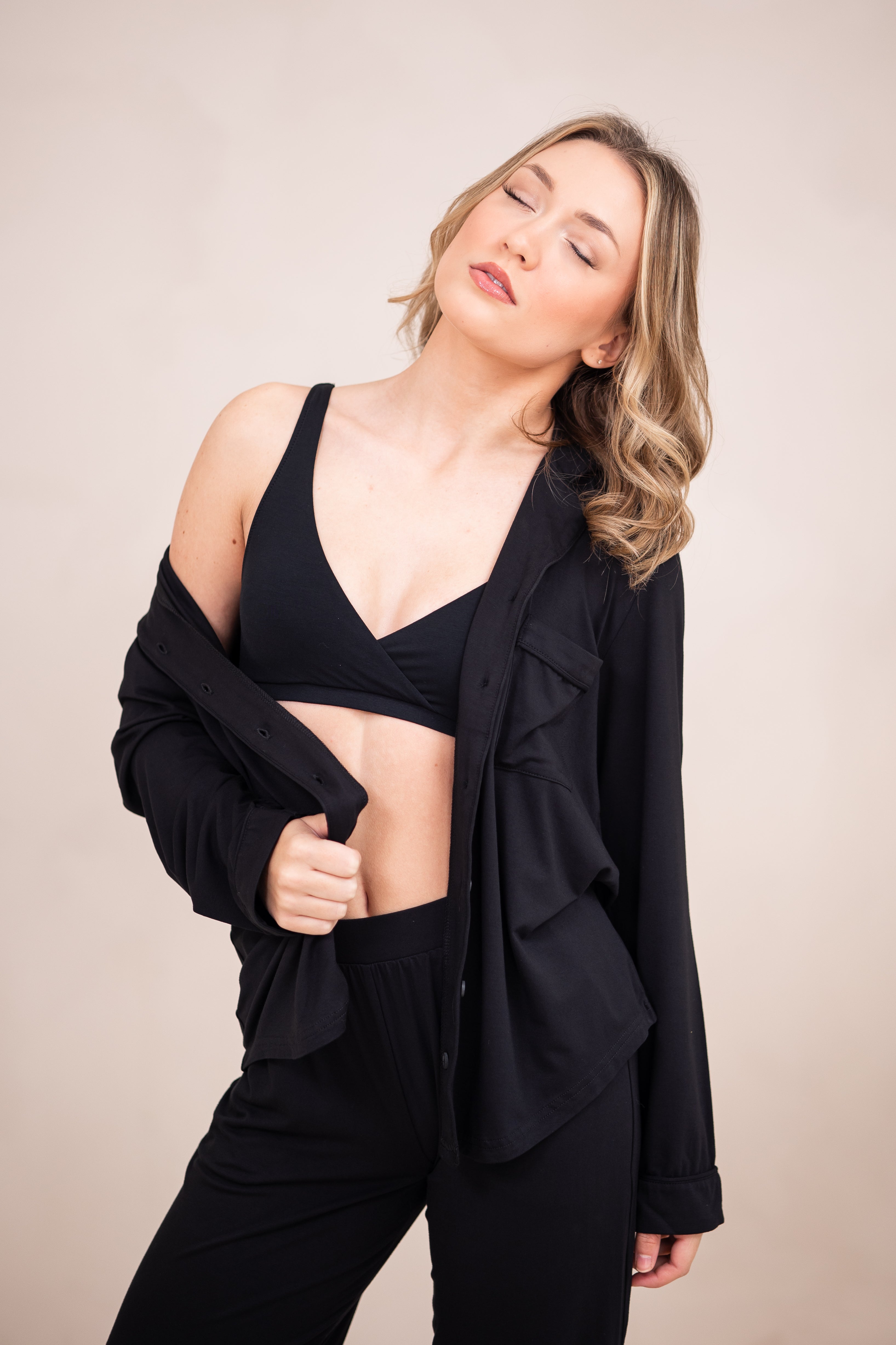 Woman modeling black cross front bralette and black pajama