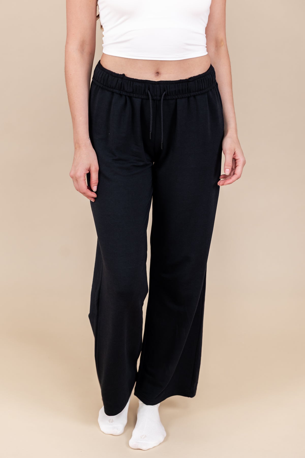 Modal wearing Women's Sweatpants in Midnight color under white flex bra tank on a beige background