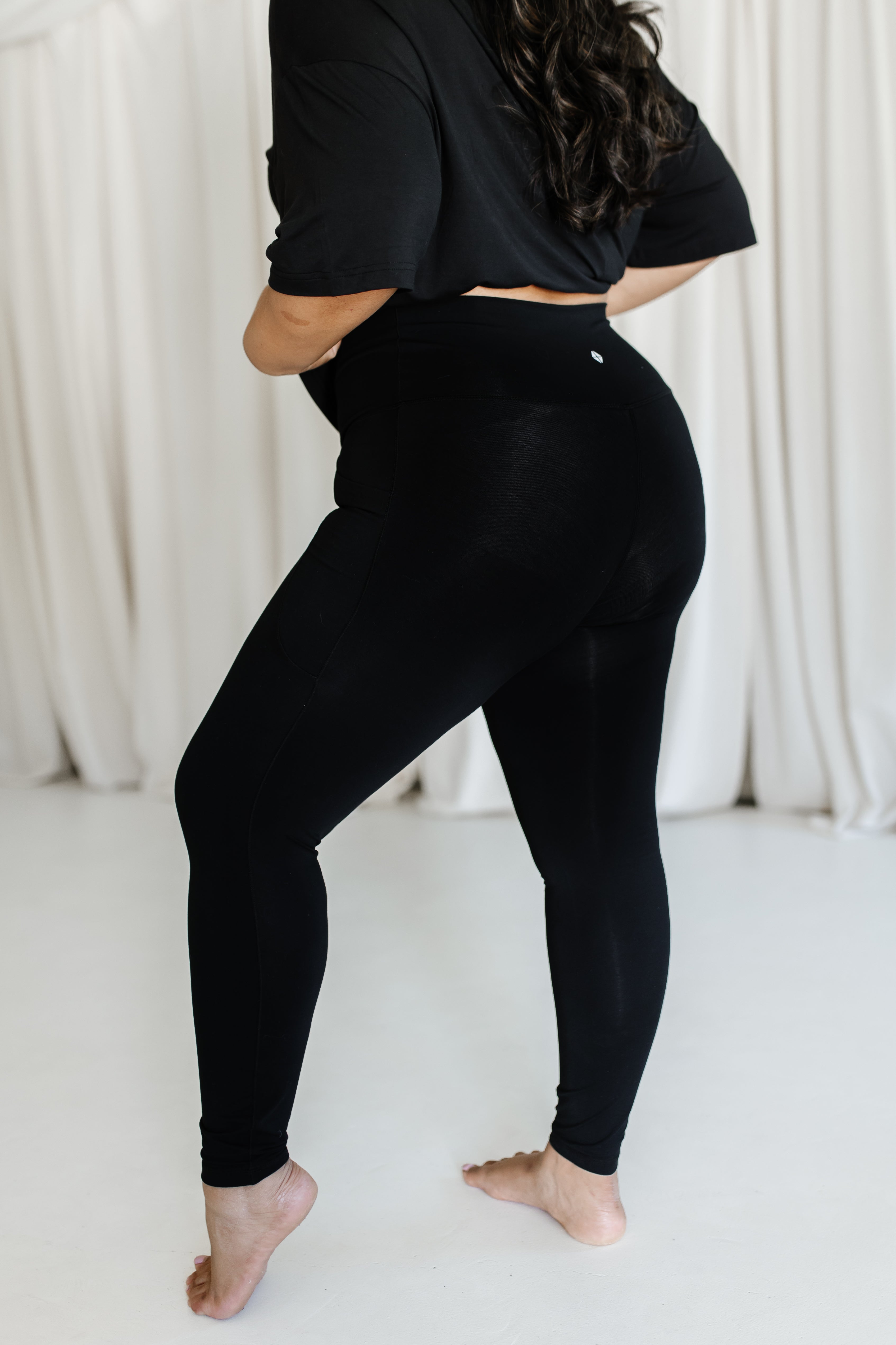 The side view of the Bamboo Flex Women’s Leggings in Midnight shown on a female model