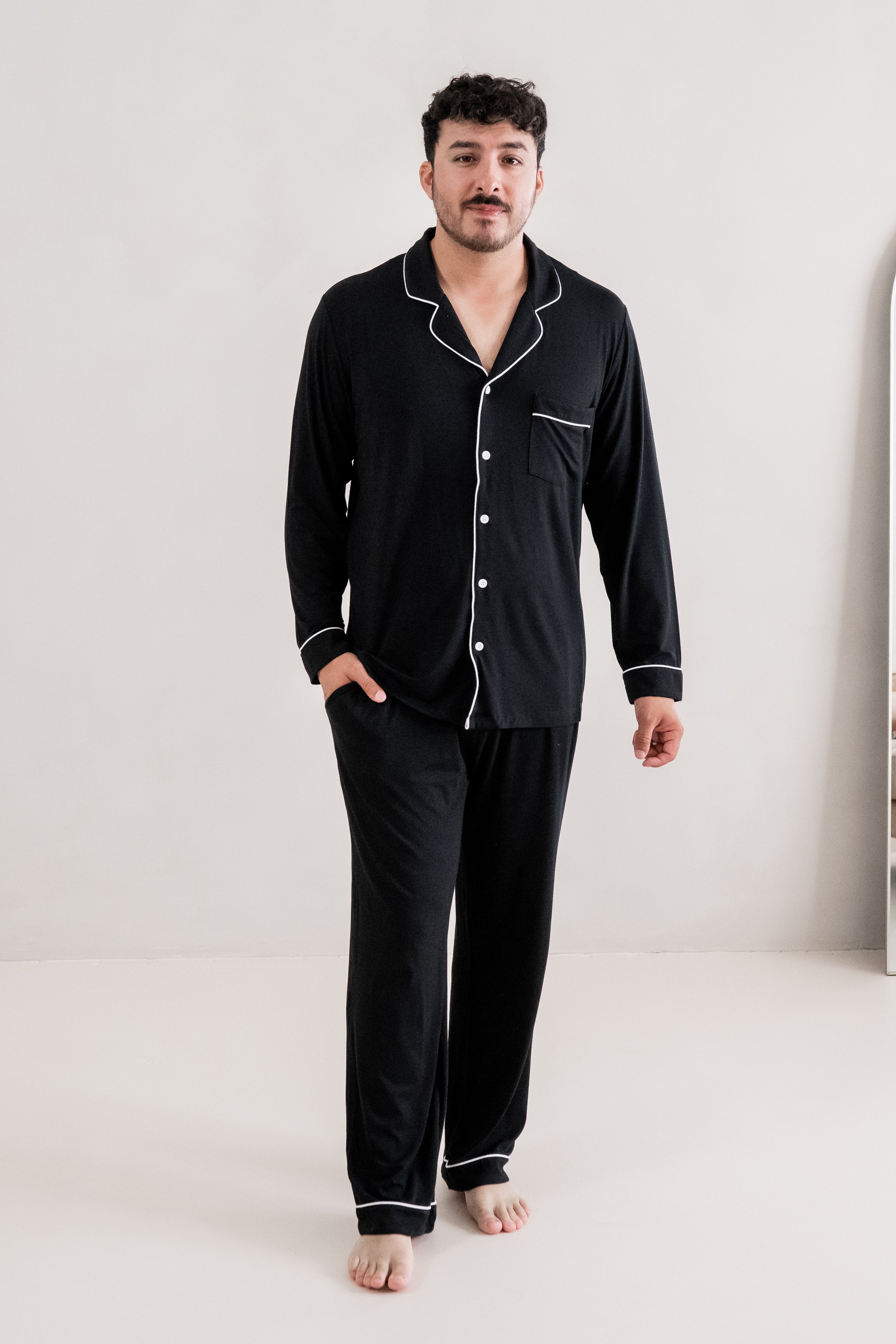 Male model walking wearing the Men's Long Sleeve Pajama Set in Midnight with one hand in the pants pocket