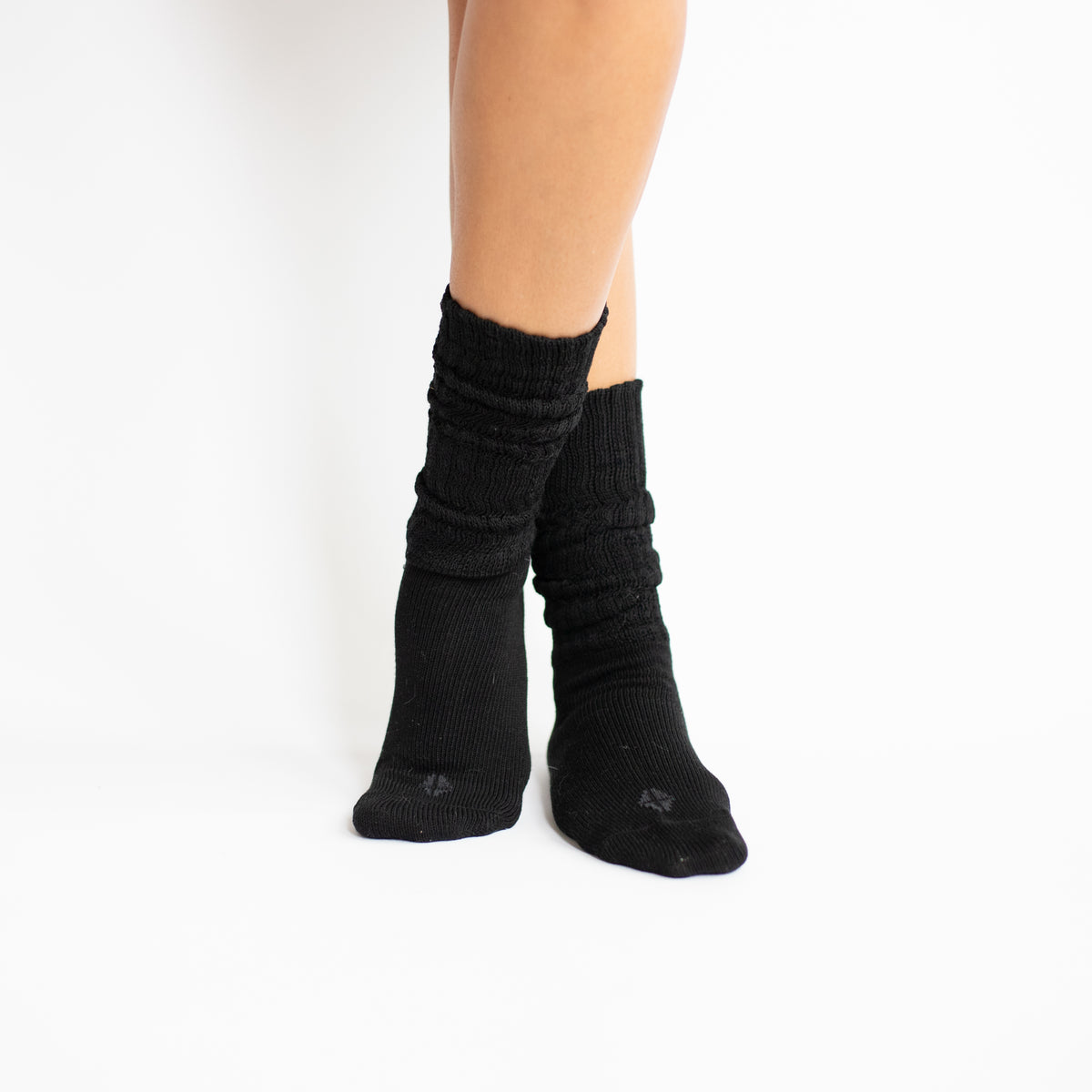 Models legs crossed together at the ankles wearing the Adult Crew Socks in Midnight