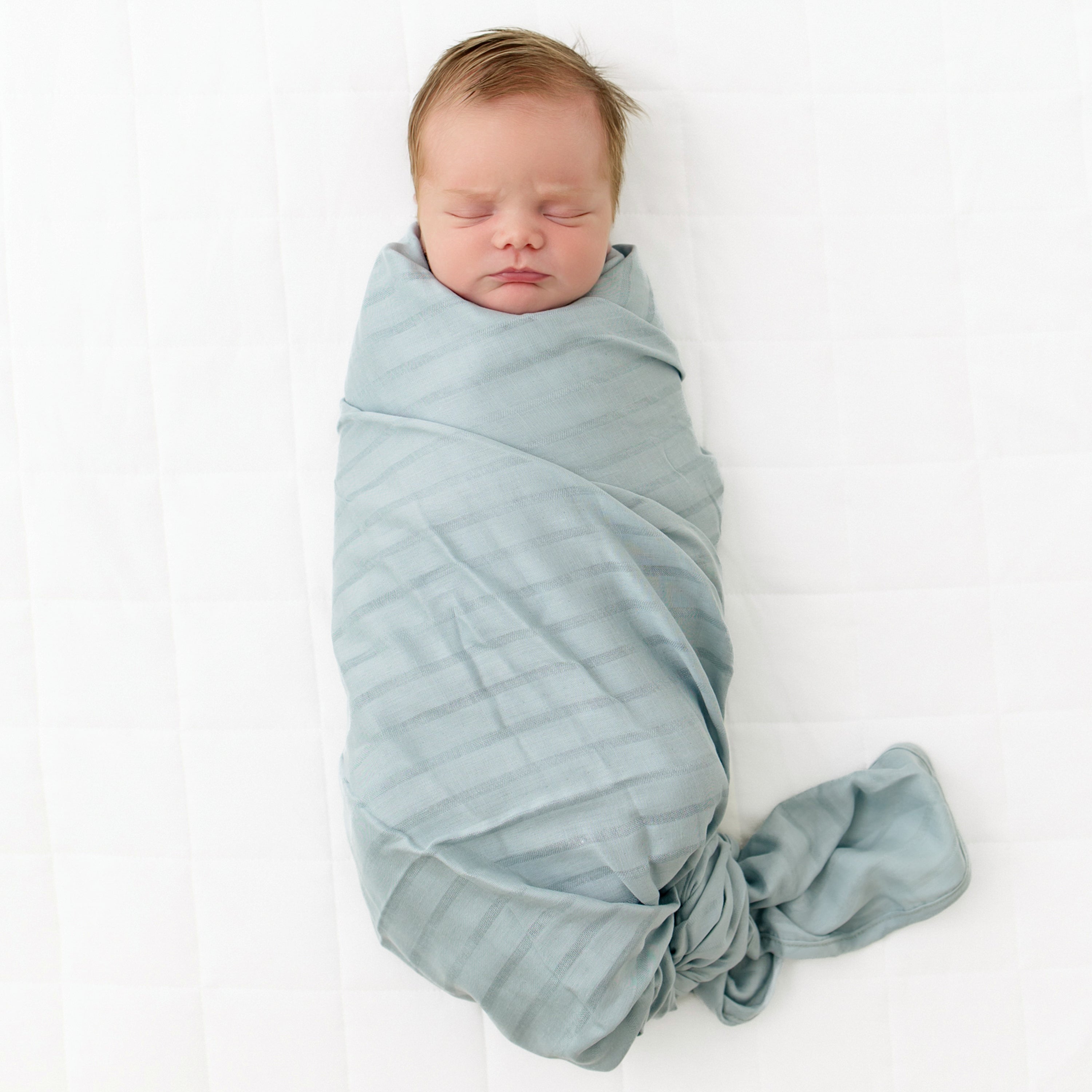 Baby swaddled in Bamboo Muslin Swaddler Blanket in Mist