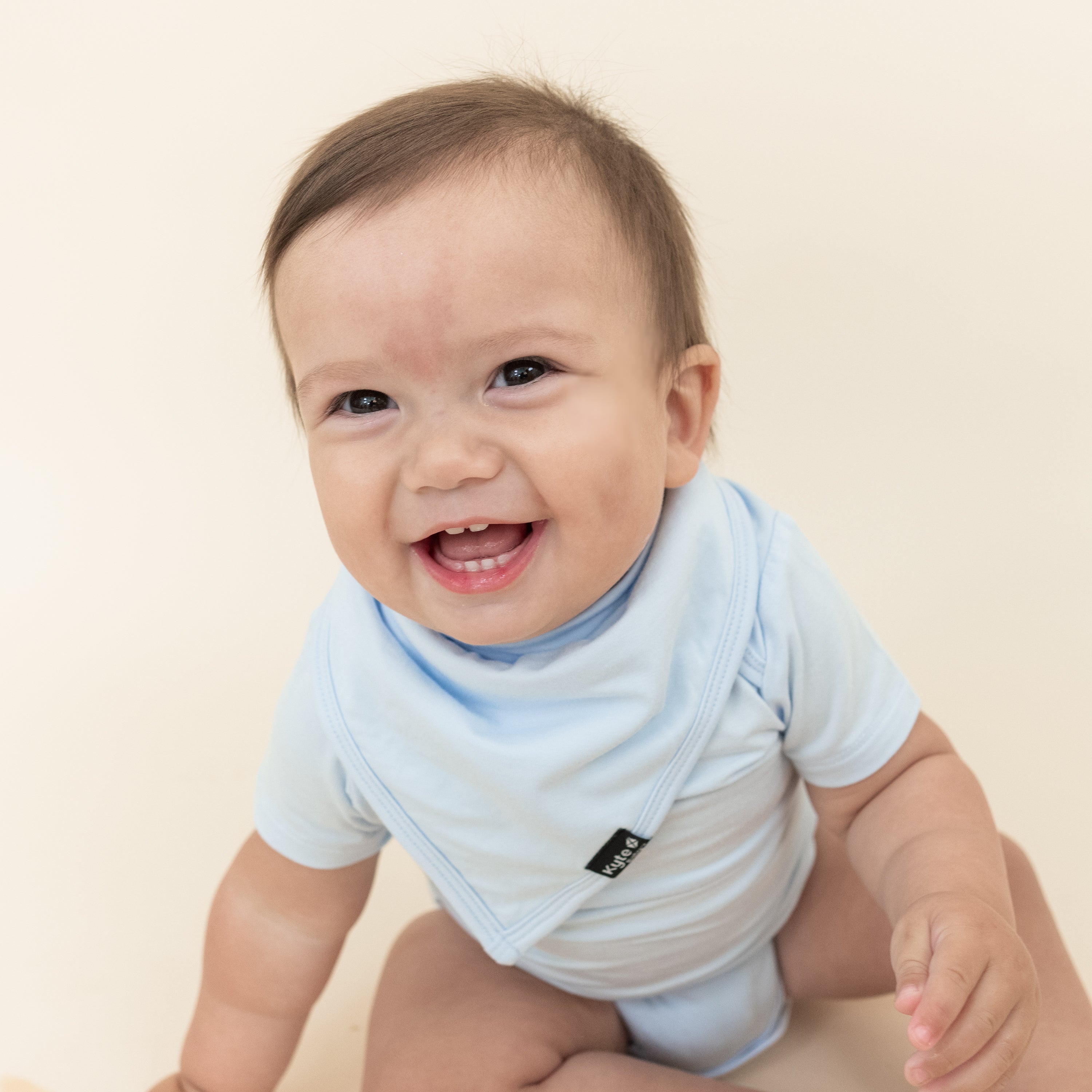 Smiling infant wearing the Bib in Mist with matching Short Sleeve Bodysuit