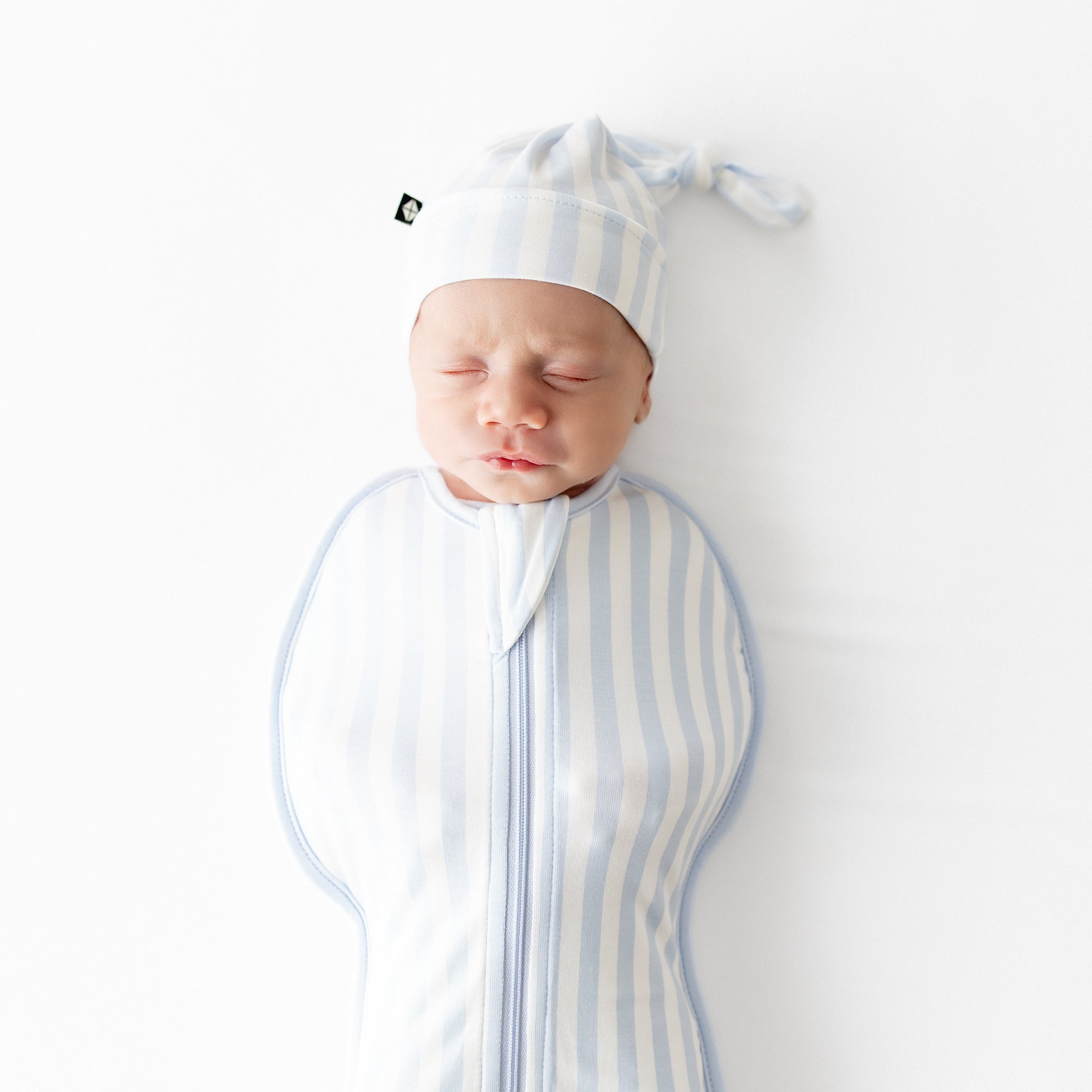 Close up of sleeping newborn wearing the Swaddle Bag in Small Mist Stripe 0.5