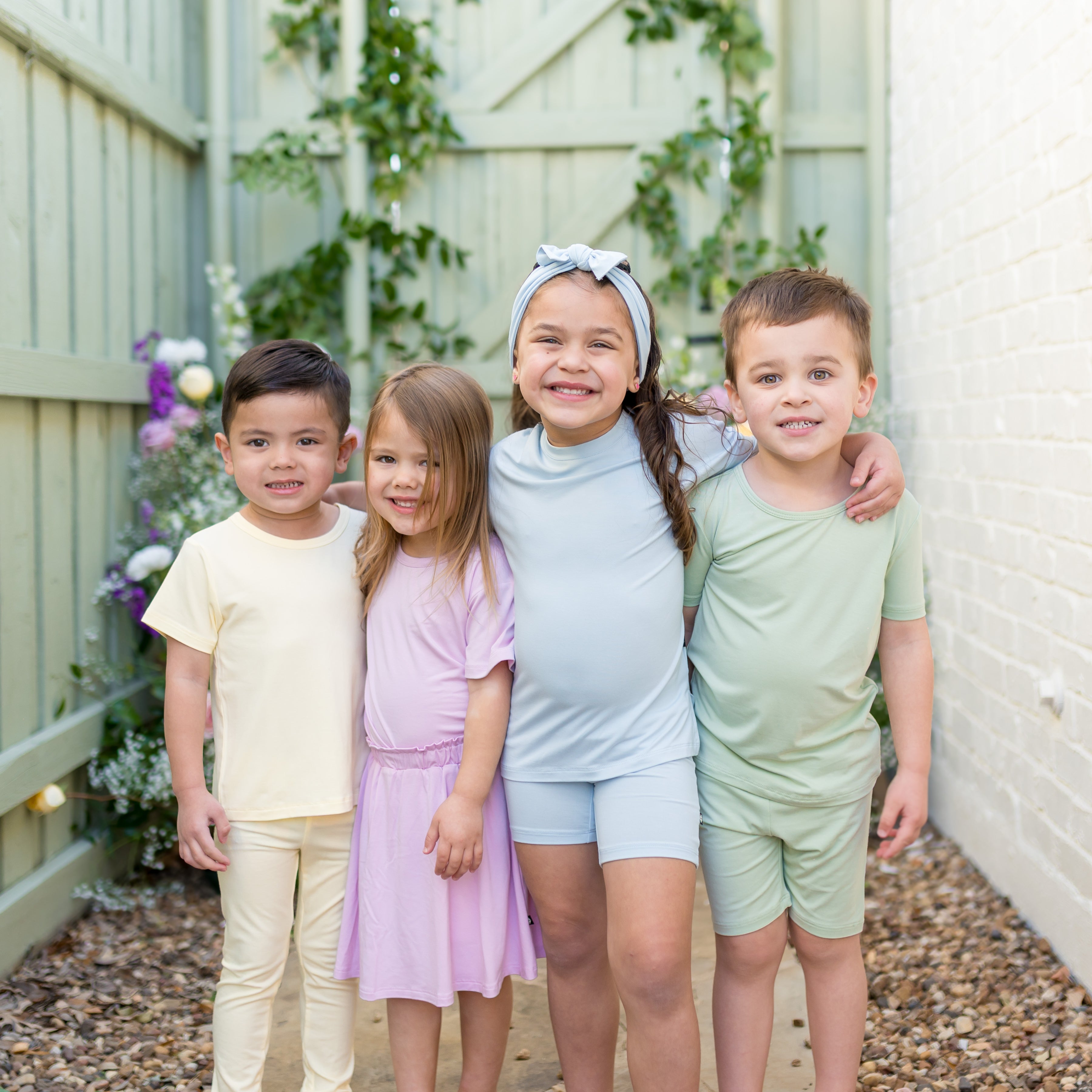 Four kids standing side by side wearing various items in spring colors