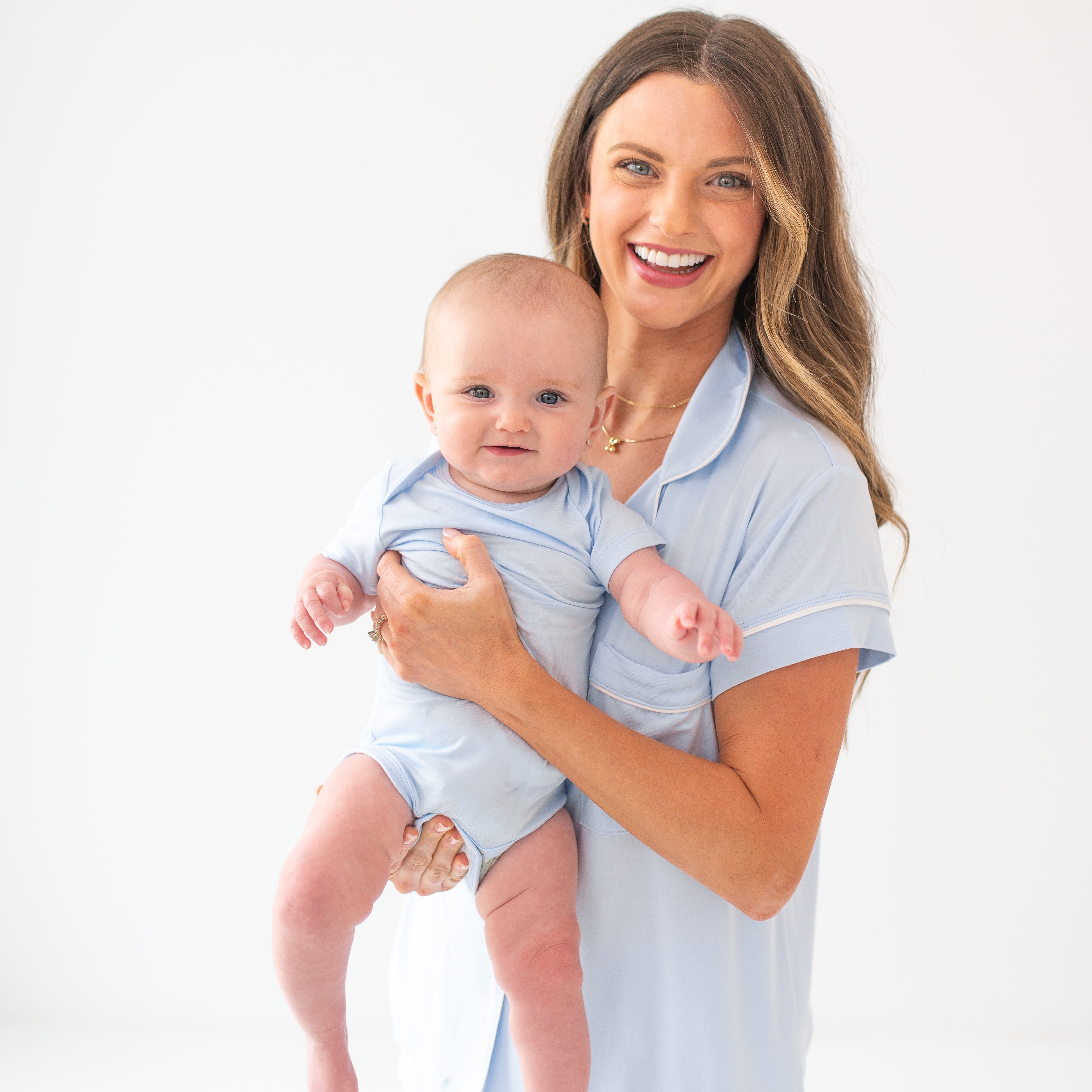 Mom wearing the Women's Short Sleeve Pajama Set in Mist holding baby wearing the Bodysuit in Mist