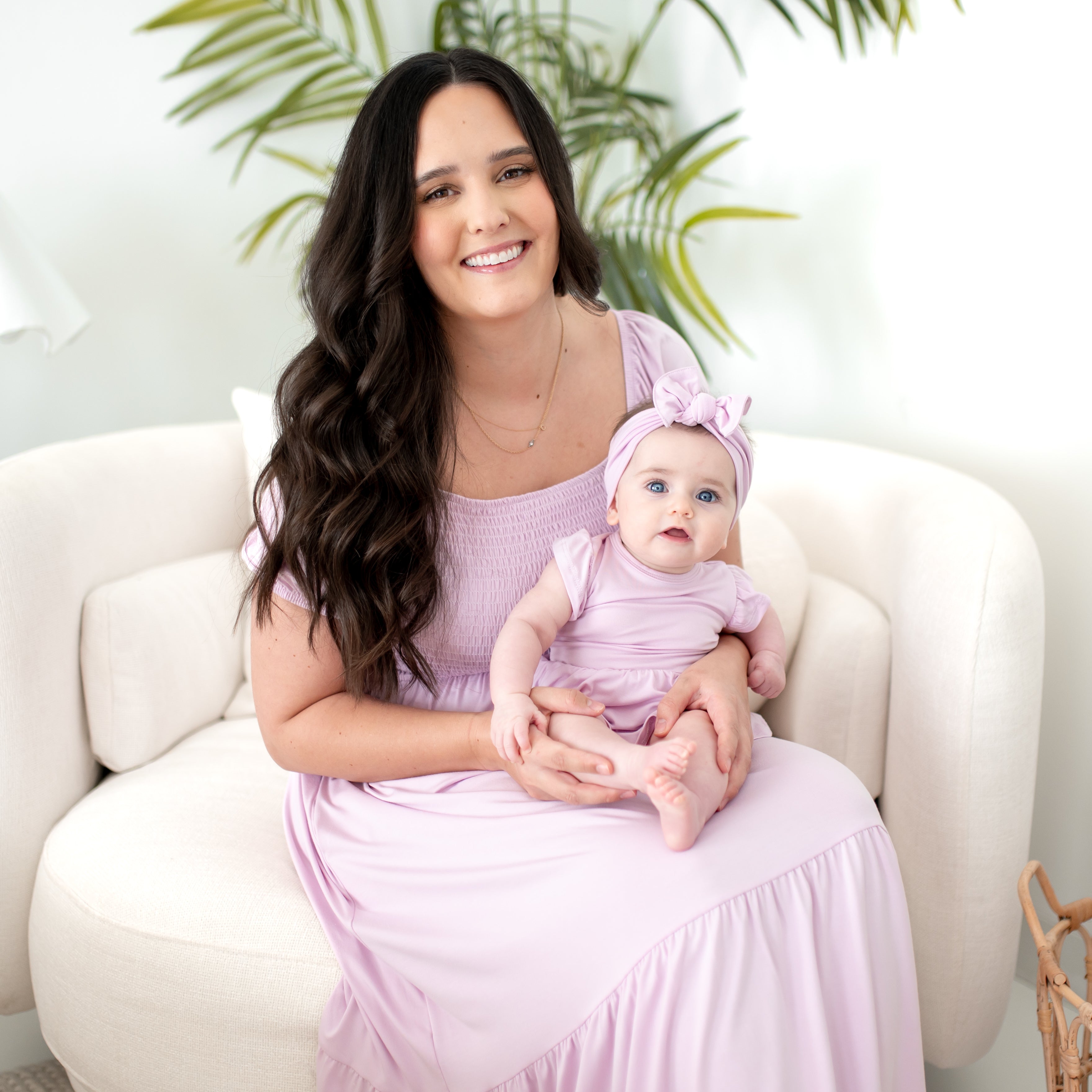 Mom and baby wearing matching light purple dresses