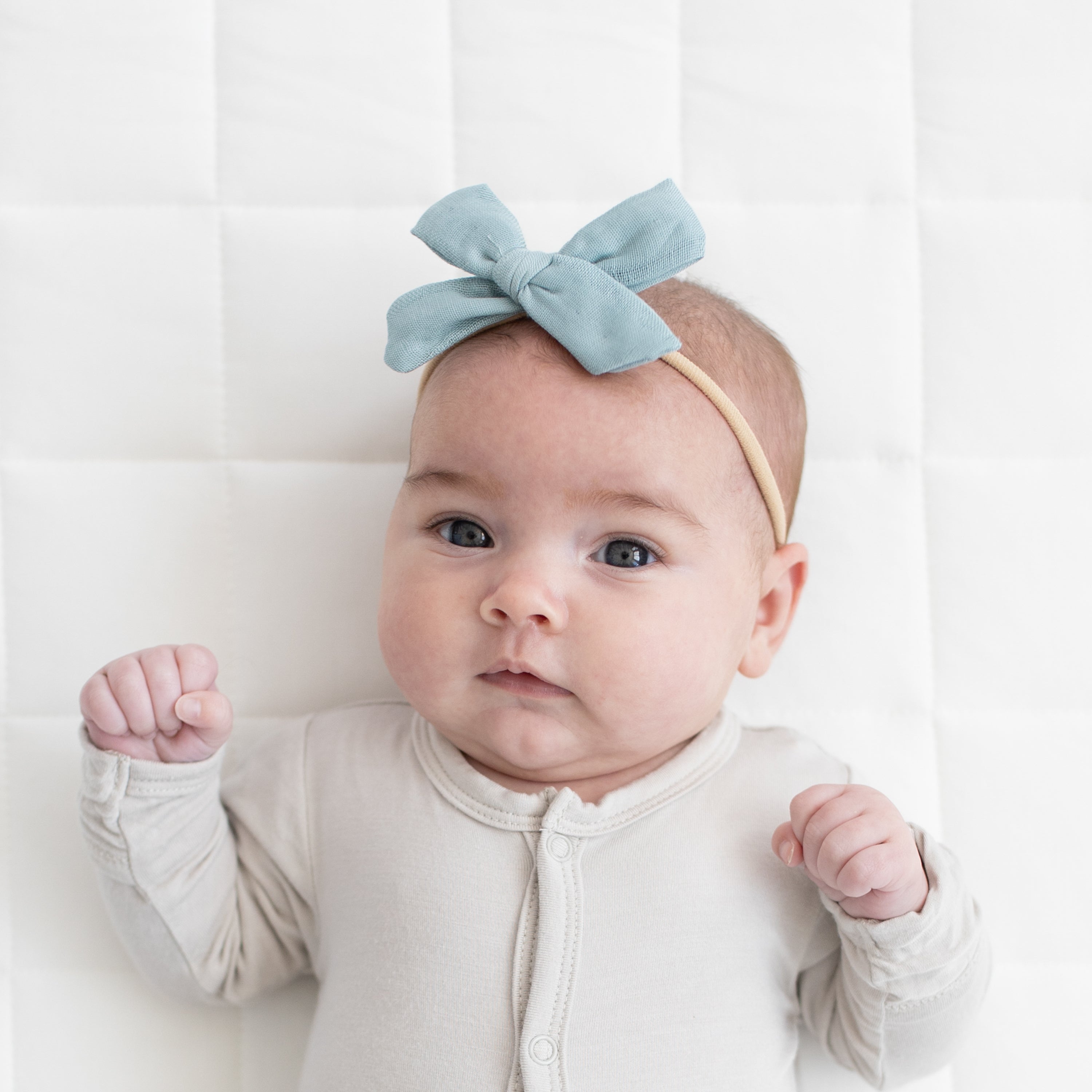 Baby wearing Medium Bamboo Muslin Bow in Mist