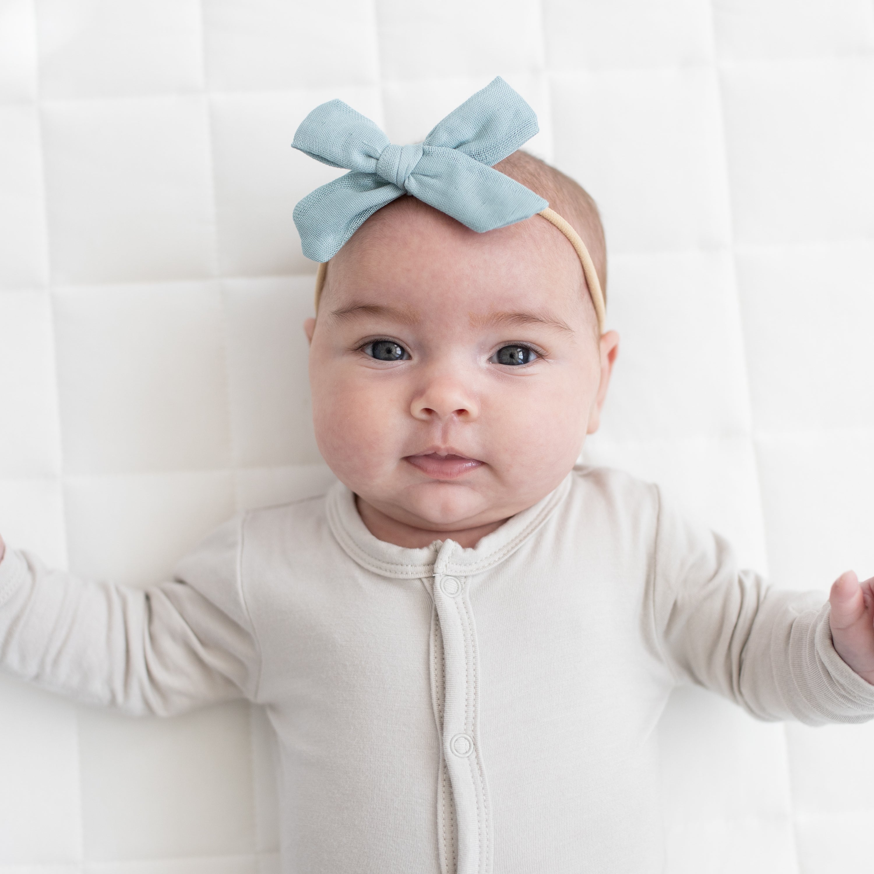 Baby wearing Medium Bamboo Muslin Bow in Mist Blue with Snap Pajamas