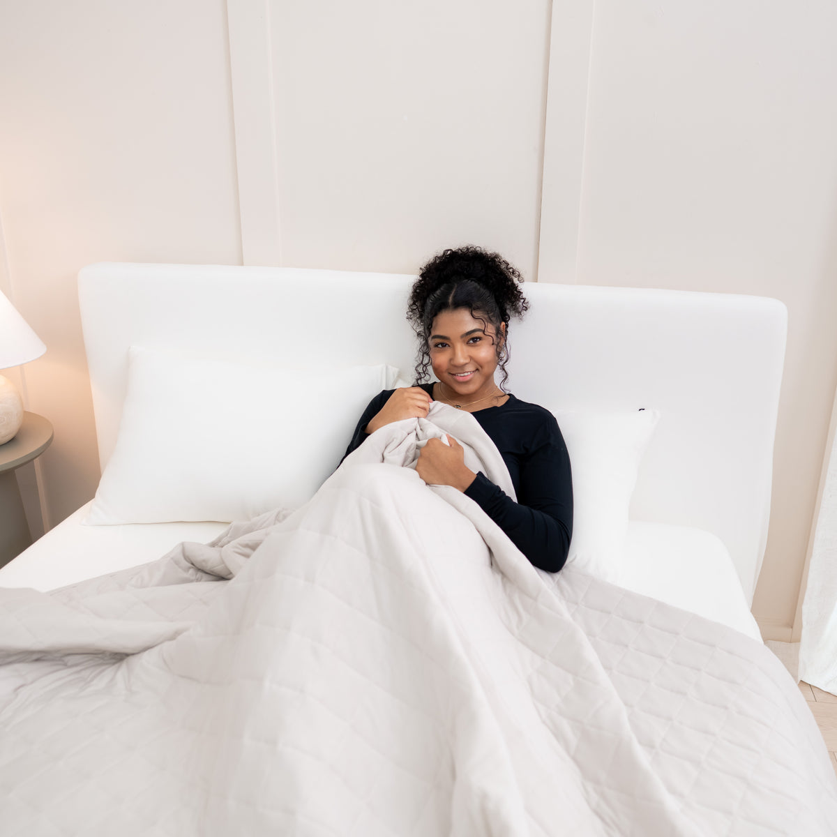 Woman in bed with Adult Quilted Blanket in Oat 2.5