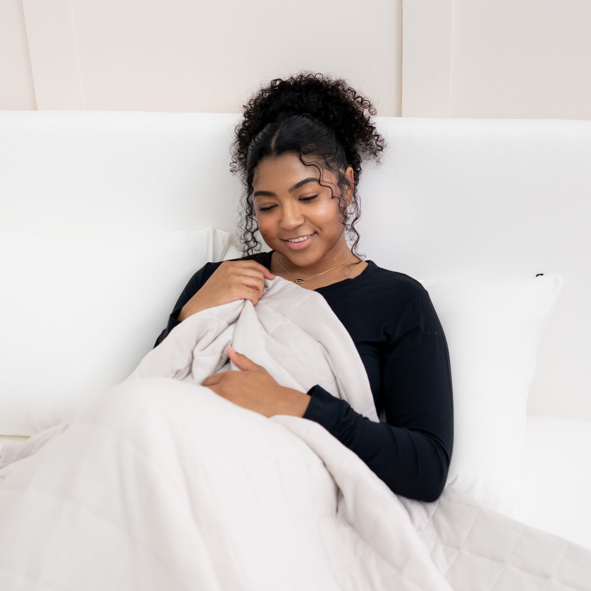 Woman snuggled with Adult Quilted Blanket in Oat 1.0