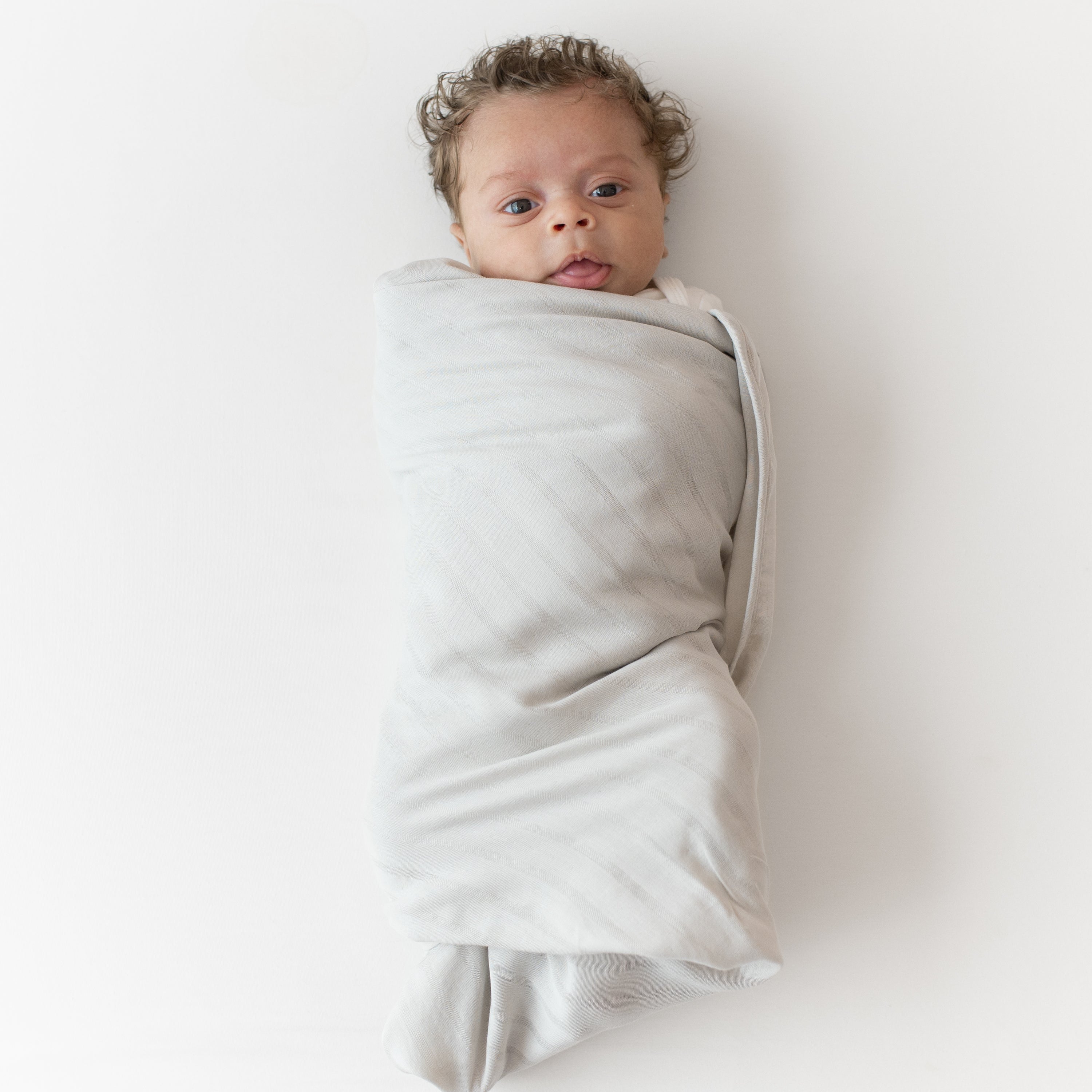 Baby swaddled in Bamboo Muslin Swaddle Blanket in Oat