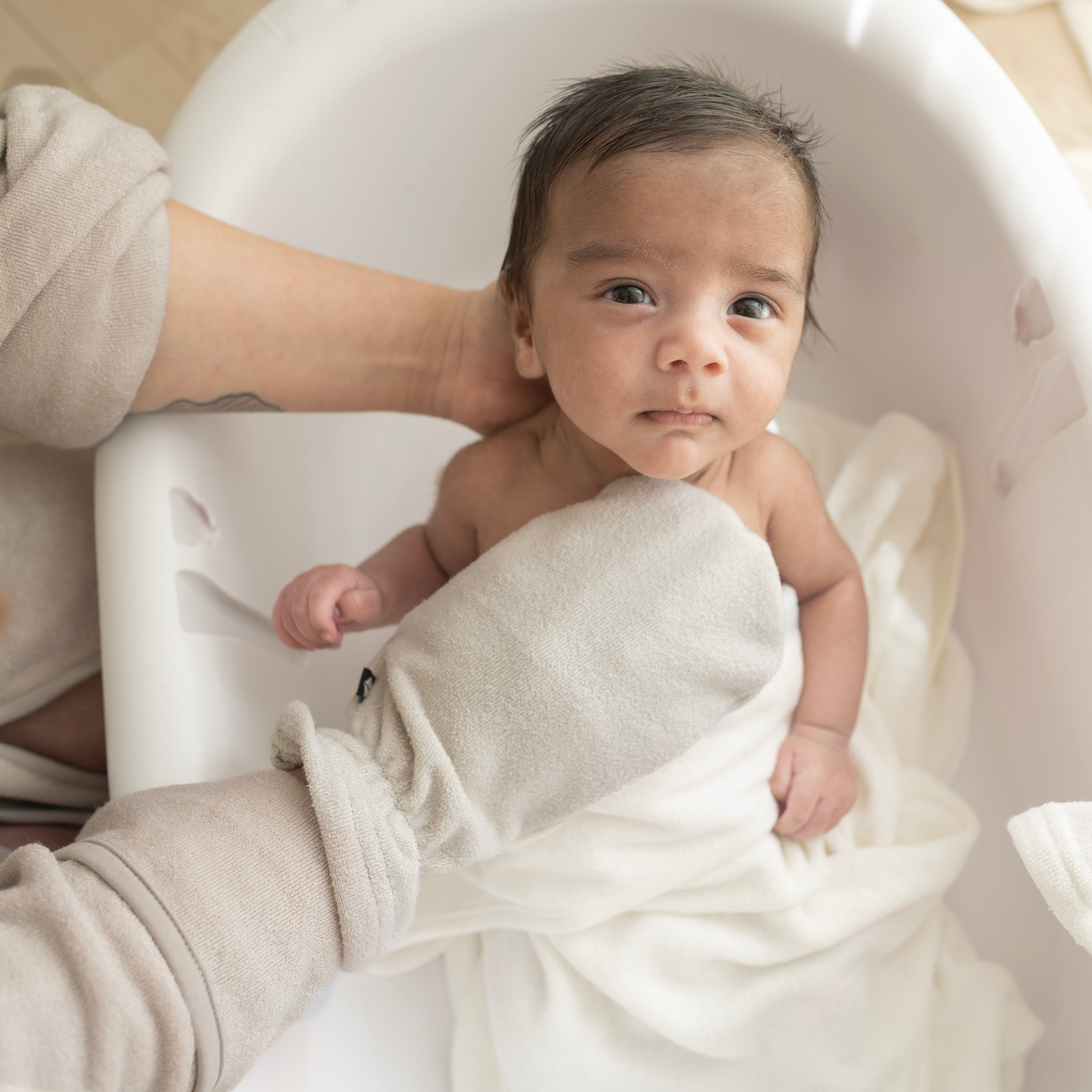 Parent bathing newborn with Terry Bath Mitt in Oat