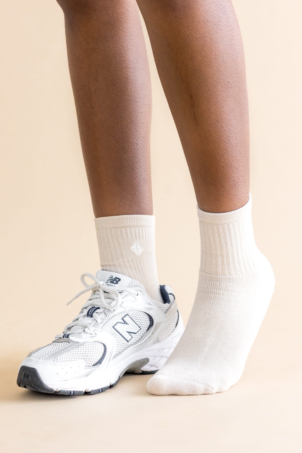Adult Crew Socks in Oat shown on models feet with a sneaker on the right foot