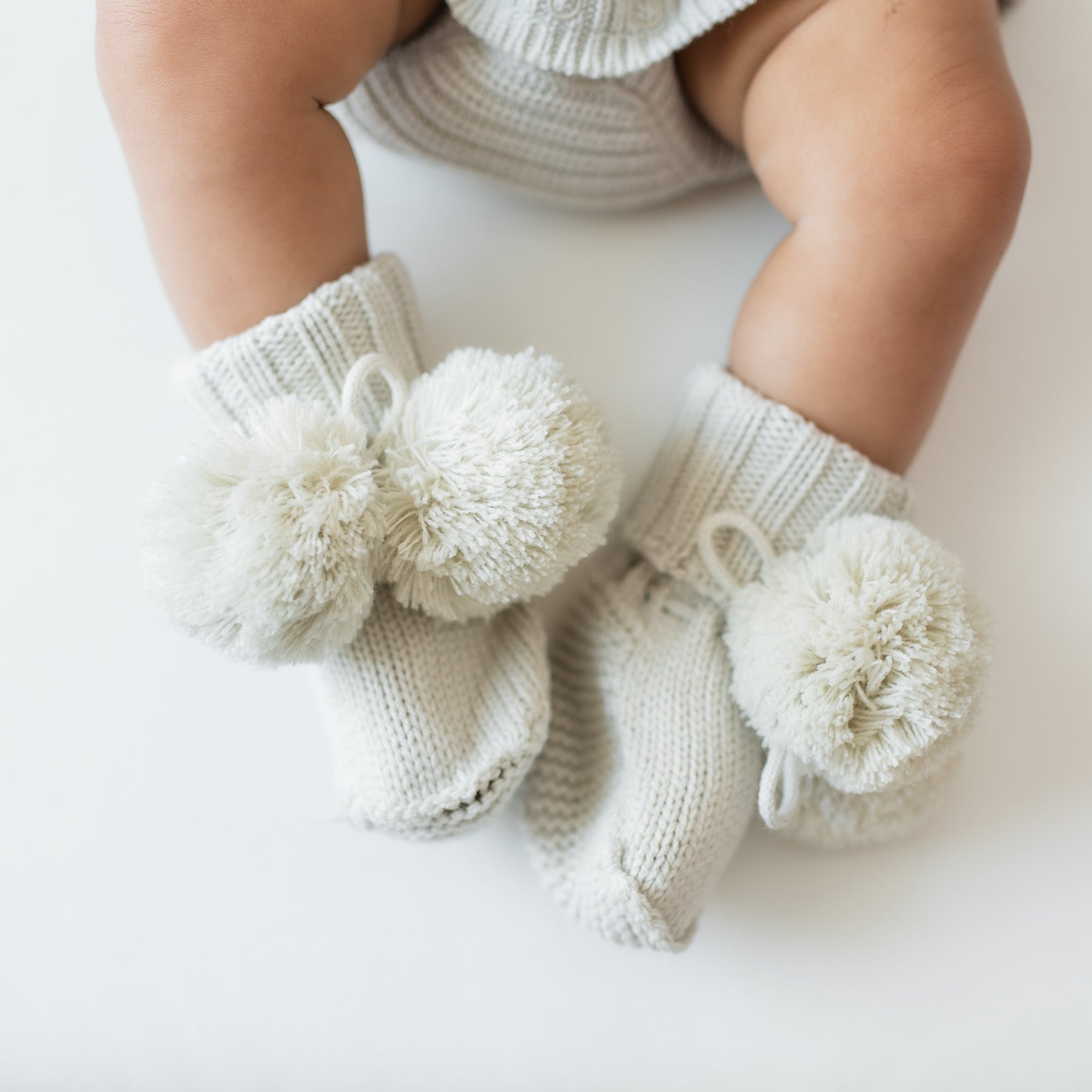 Knit Booties in Oat shown on an infant