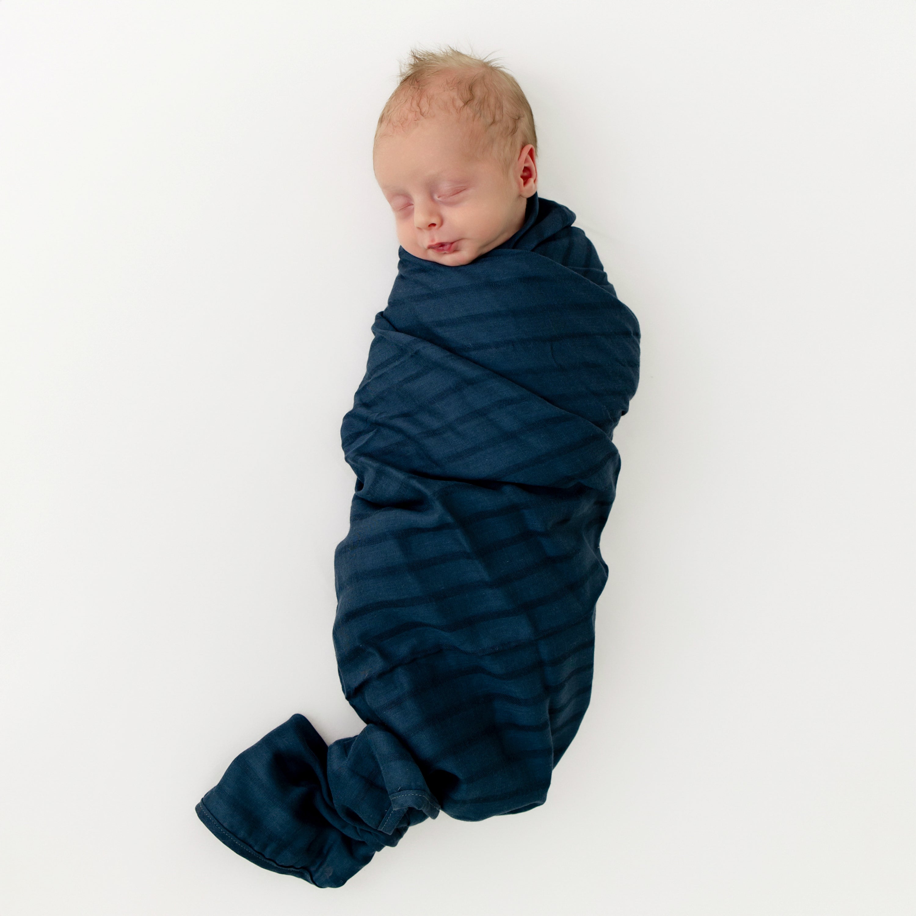 Newborn swaddled in Bamboo Muslin Swaddle Blanket in Oxford Blue