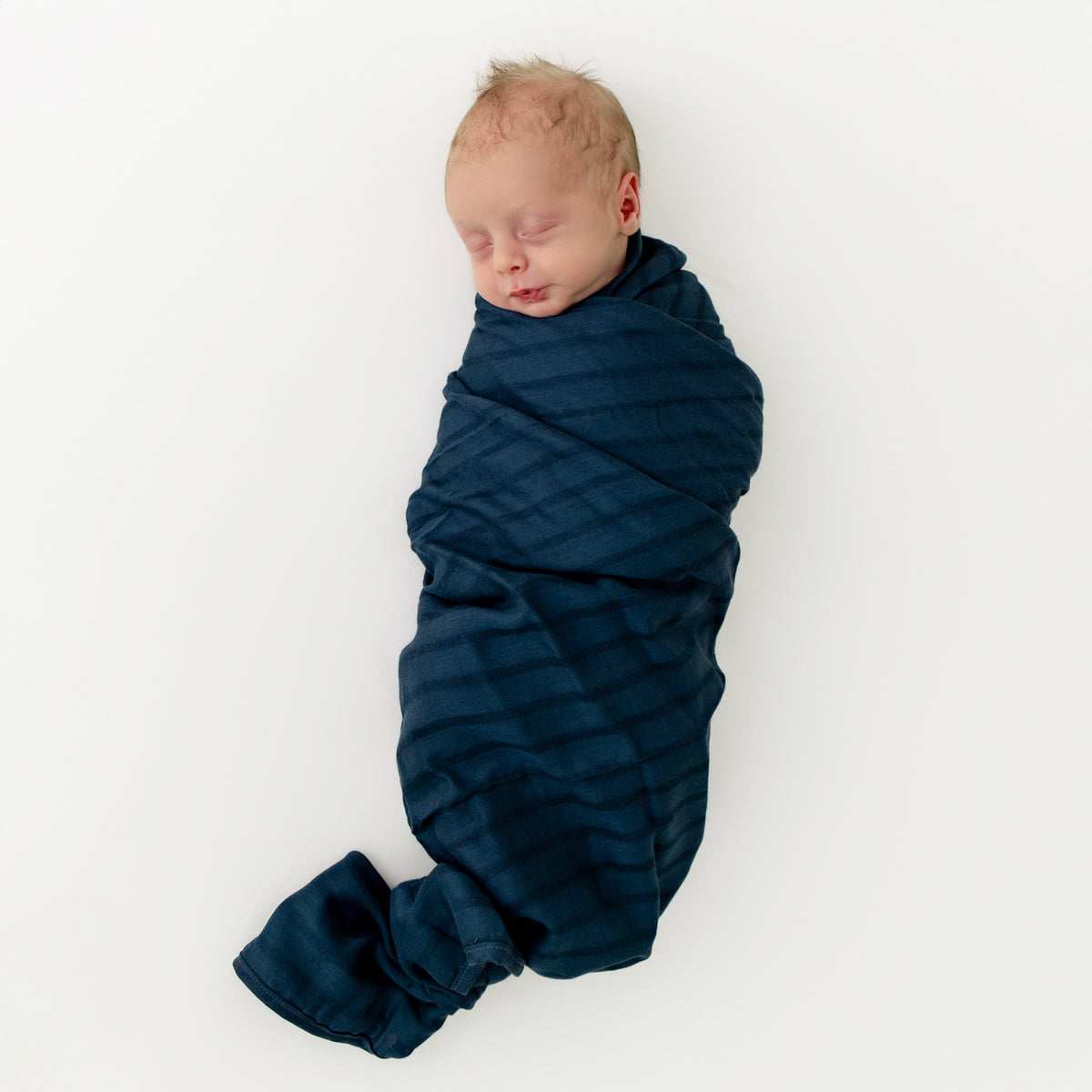 Newborn swaddled in Bamboo Muslin Swaddle Blanket in Oxford Blue