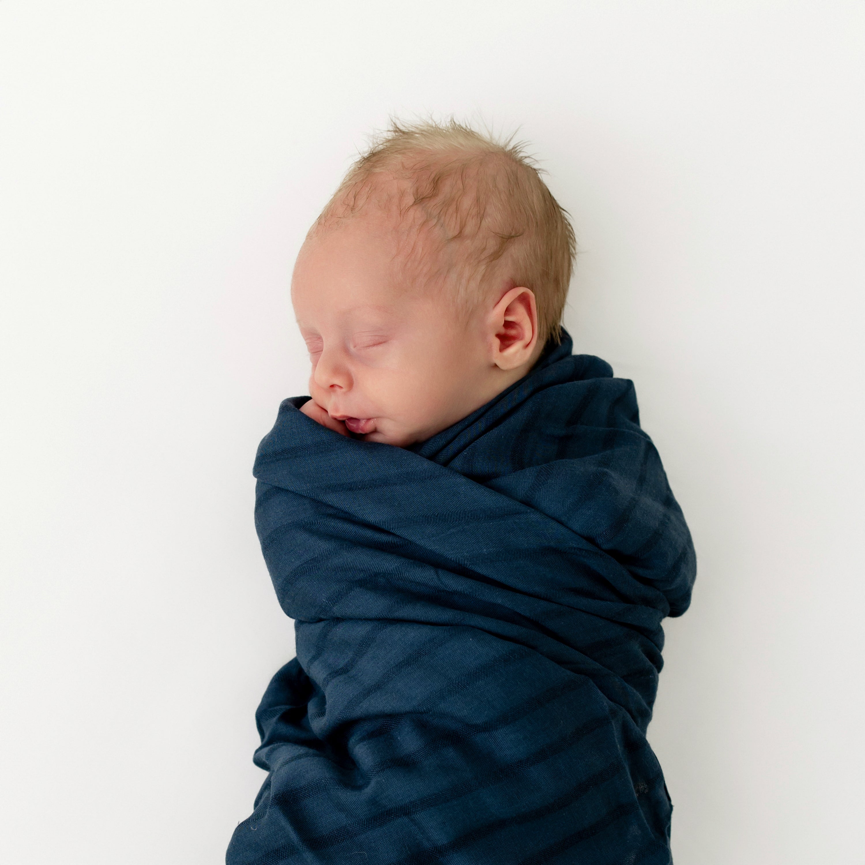 Newborn swaddled in Breathable Bamboo Muslin Swaddler Blanket in Oxford