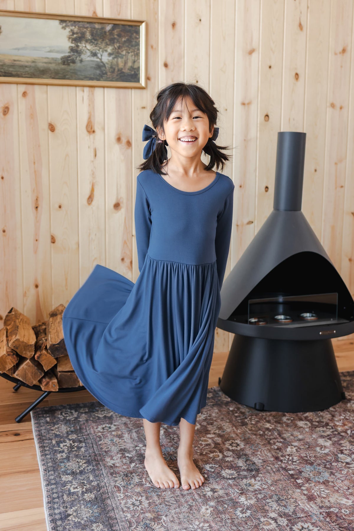 Girl wearing Long Sleeve Twirl Dress in Oxford standing near a chimney