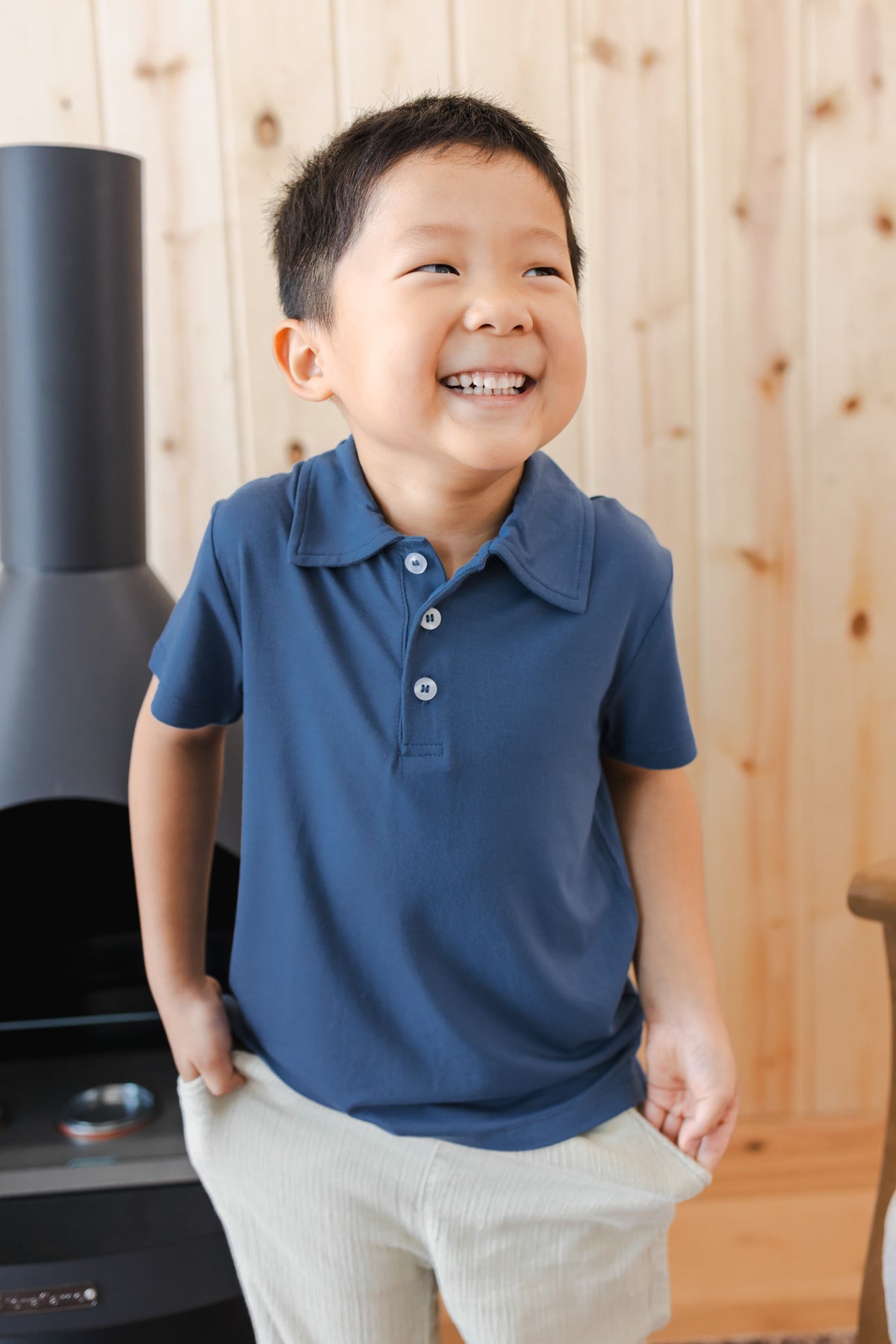 Toddler smiling in Toddler Short Sleeve Polo in Oxford over white pants