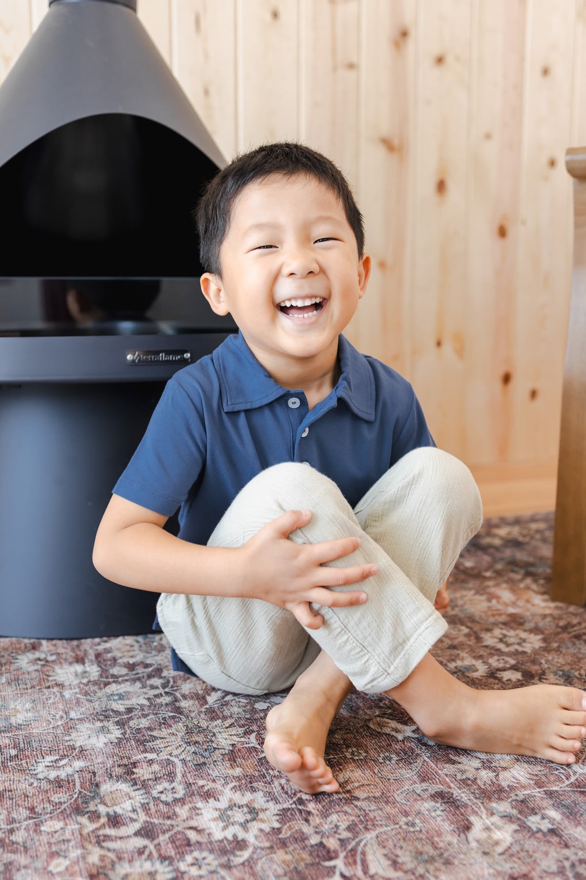 Toddler laughing in Toddler Short Sleeve Polo in Oxford wearing it over white pants