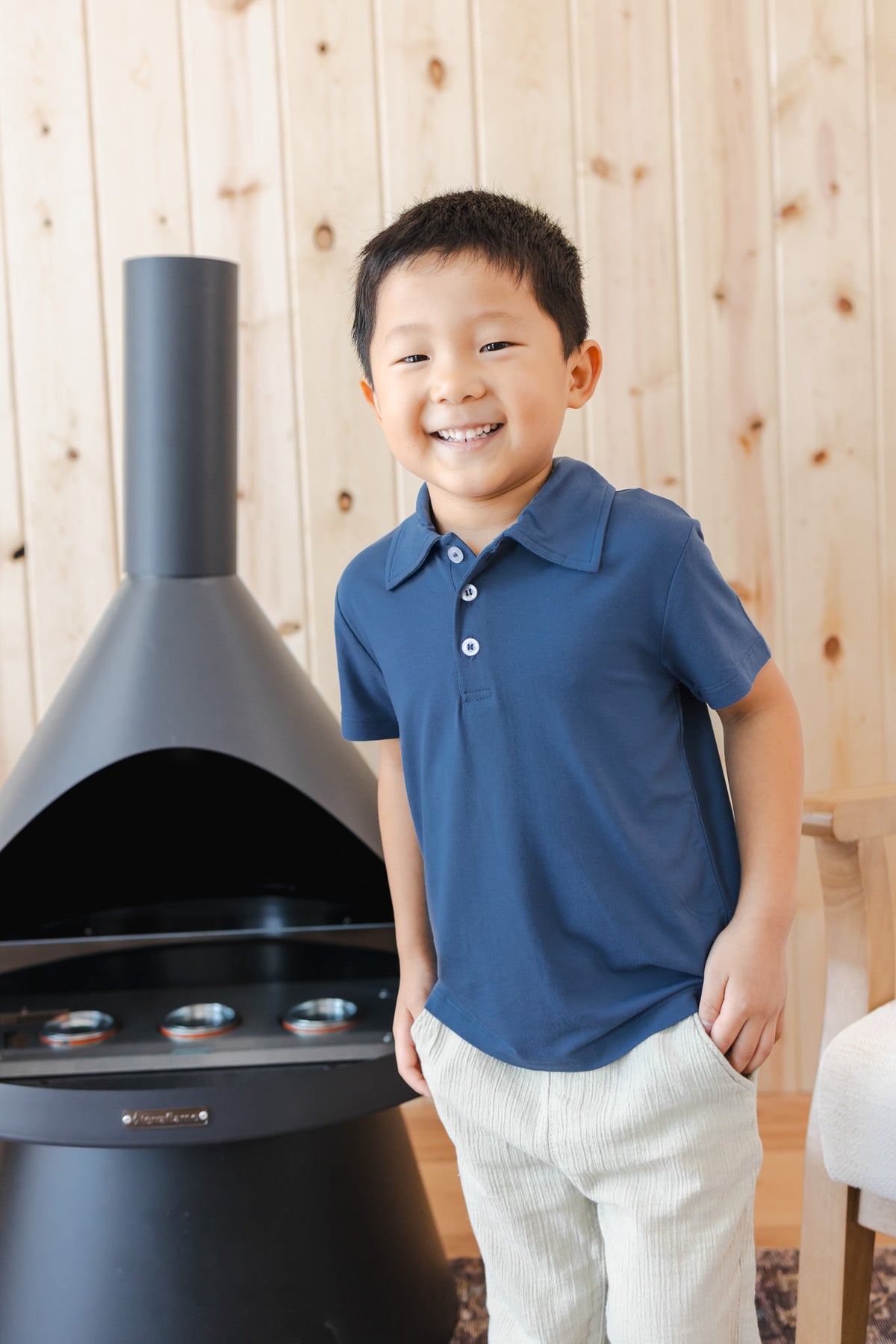 Toddler wearing Toddler Short Sleeve Polo in Oxford over white pants near chimney