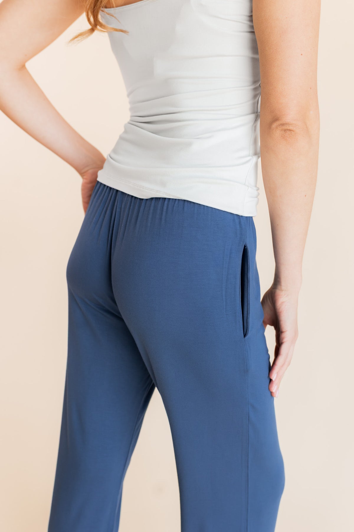 Back side of Model wearing Women's Lounge Pants in Oxford under a white camisole on a beige background