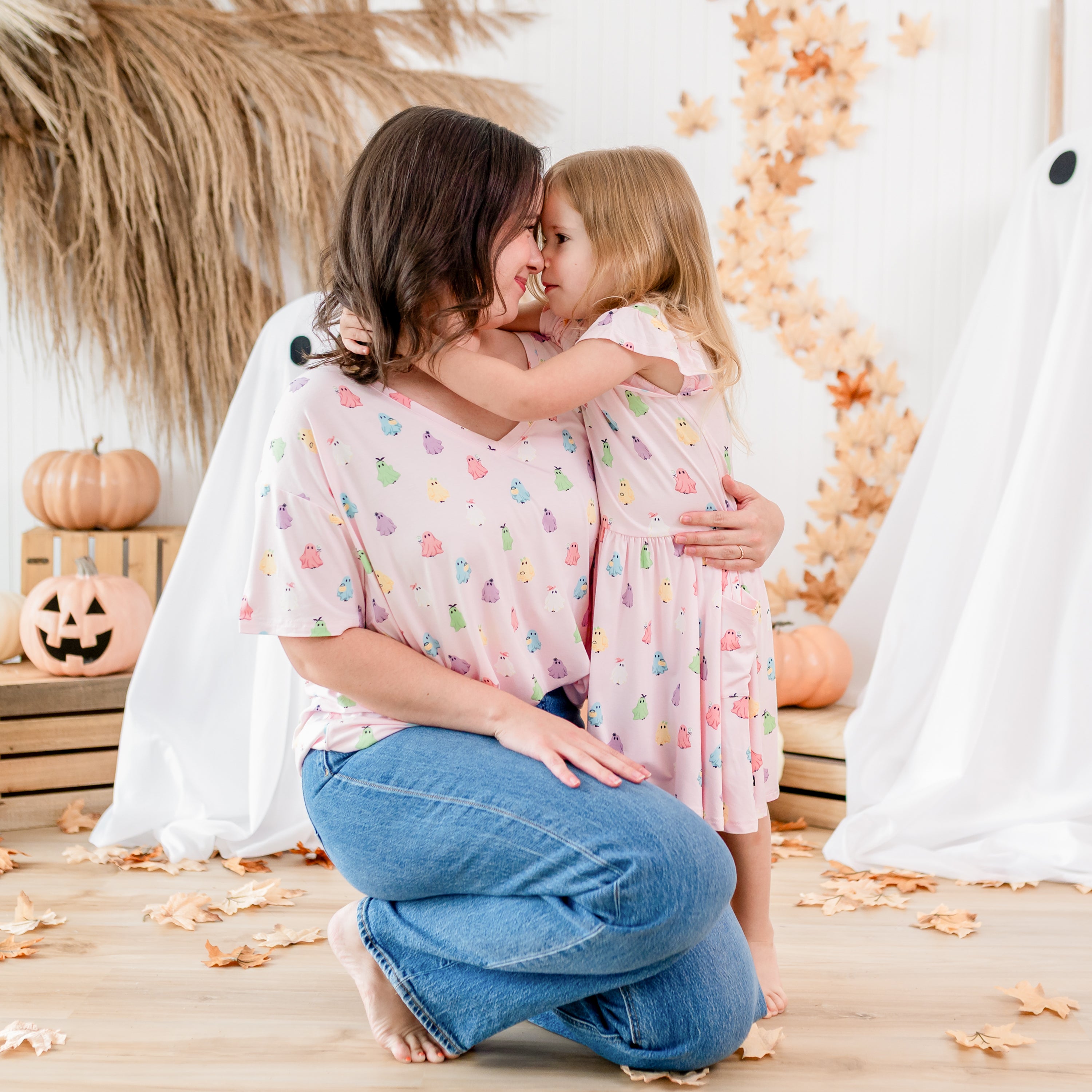 Mother and daughter matching in Pastel Ghost in front of a fall backdrop. Mother kneeling beside daughter wearing the Women's Relaxed Fit V-Neck in Pastel Ghost holding her daughter who has her face pressed up to her mothers face wearing the pocket dress