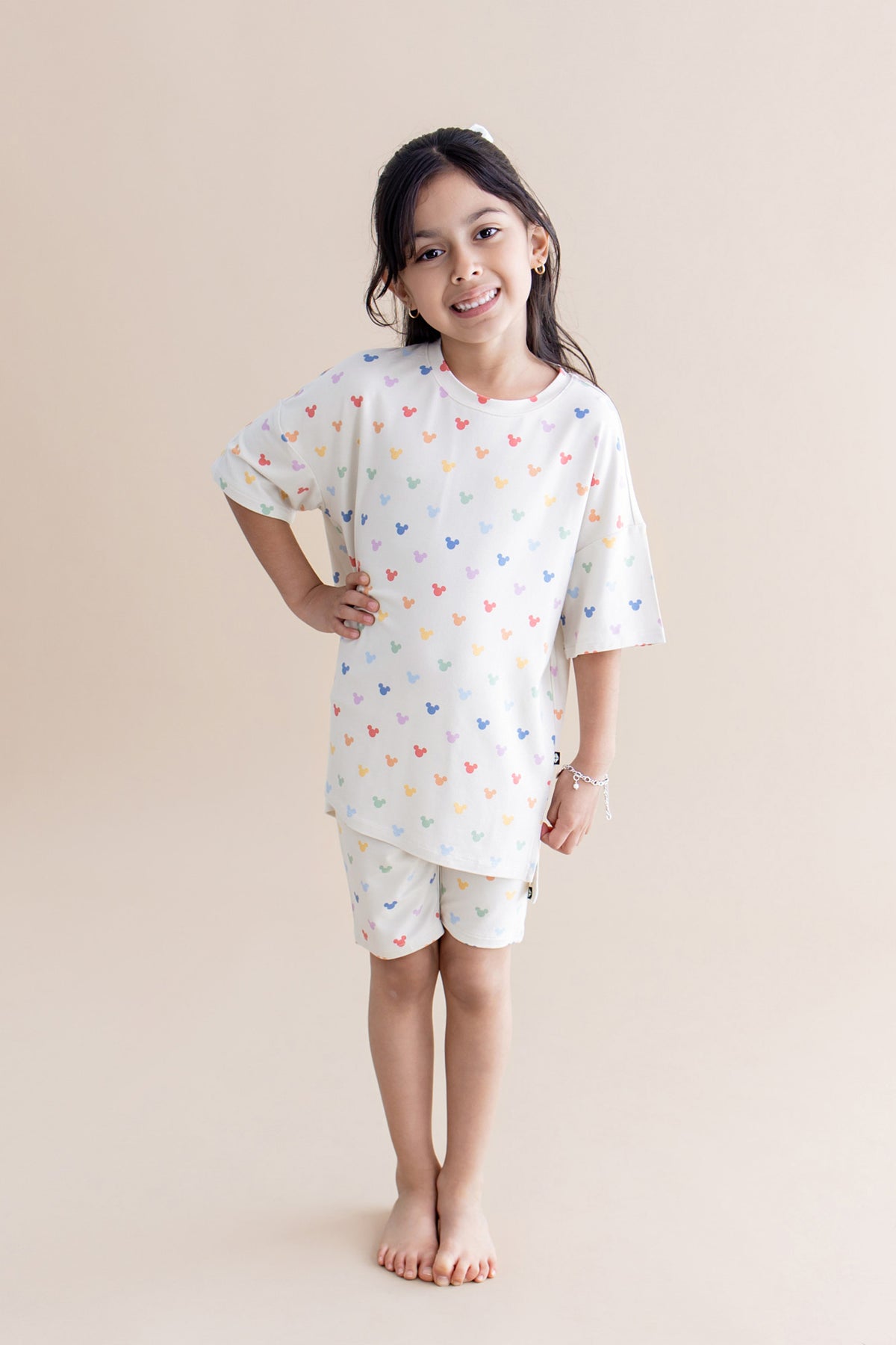 Girl in biker short set with a colorful pattern of mickey heads