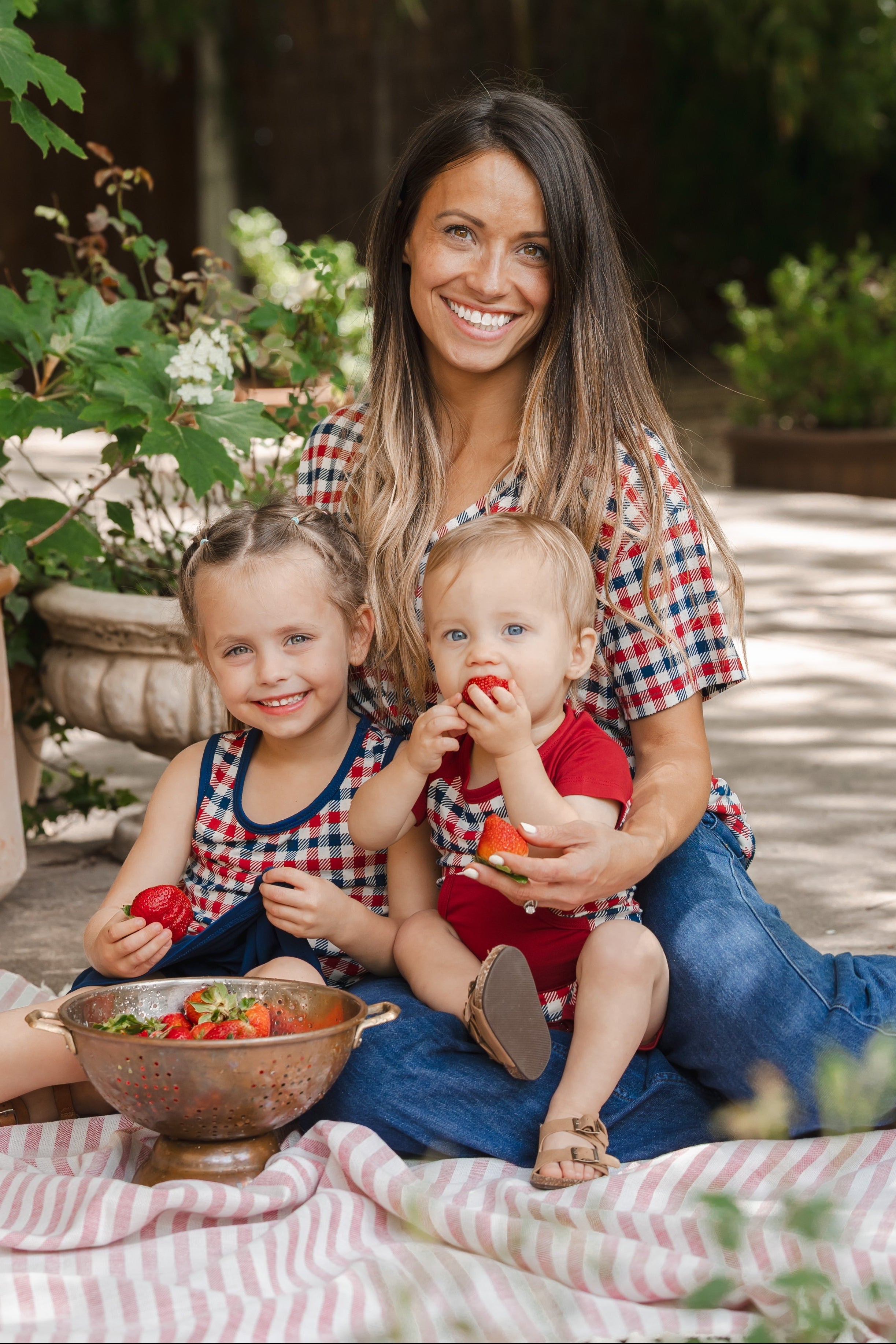 family of 3 wearing matching patriotic red white and blue gingham outfits