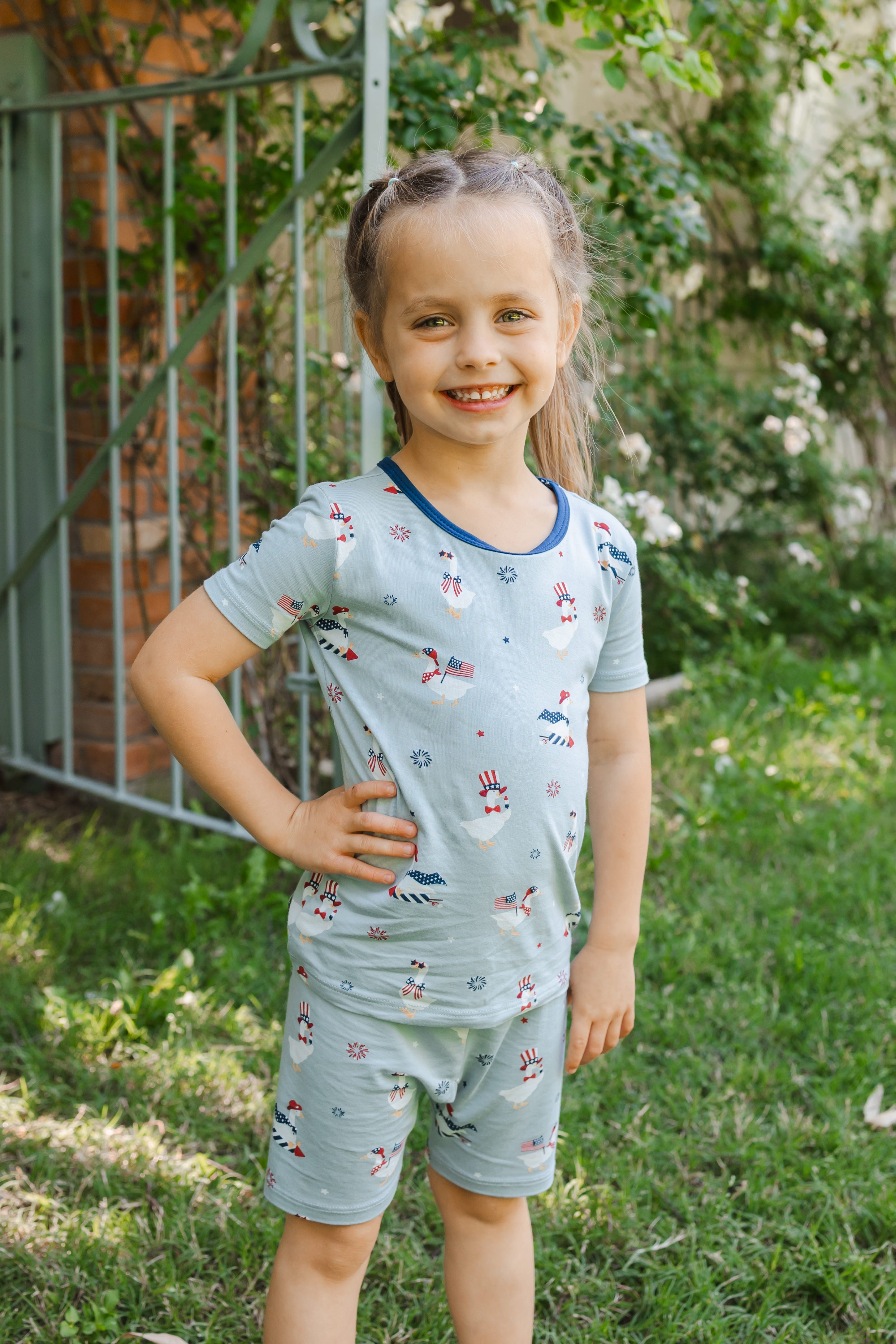 Child posing in light blue Short Sleeve Pajamas in Patriotic Goose print outdoors