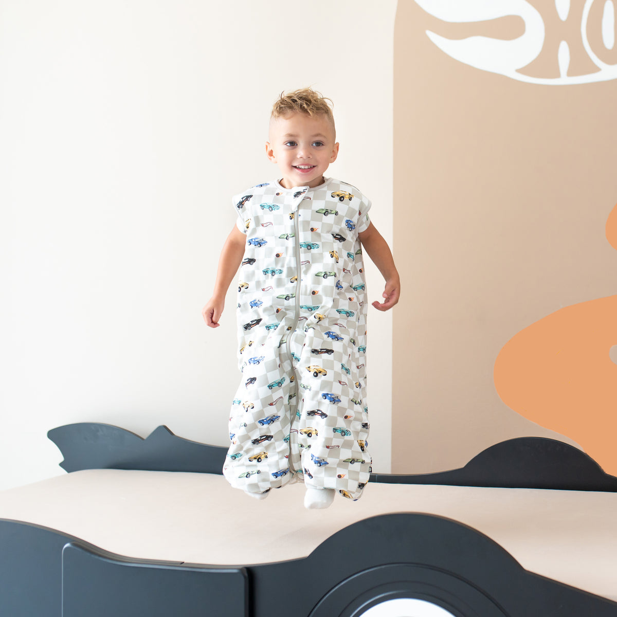 Child jumping on a bed wearing the Sleep Bag Walker in Fast and Fierce 1.0