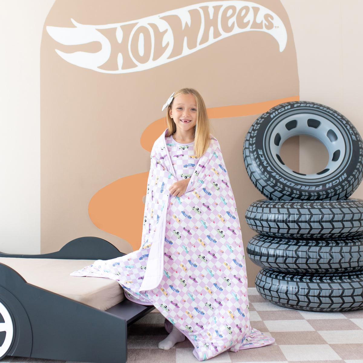 Young girl standing with the Youth Blanket in Sparkles and Speed