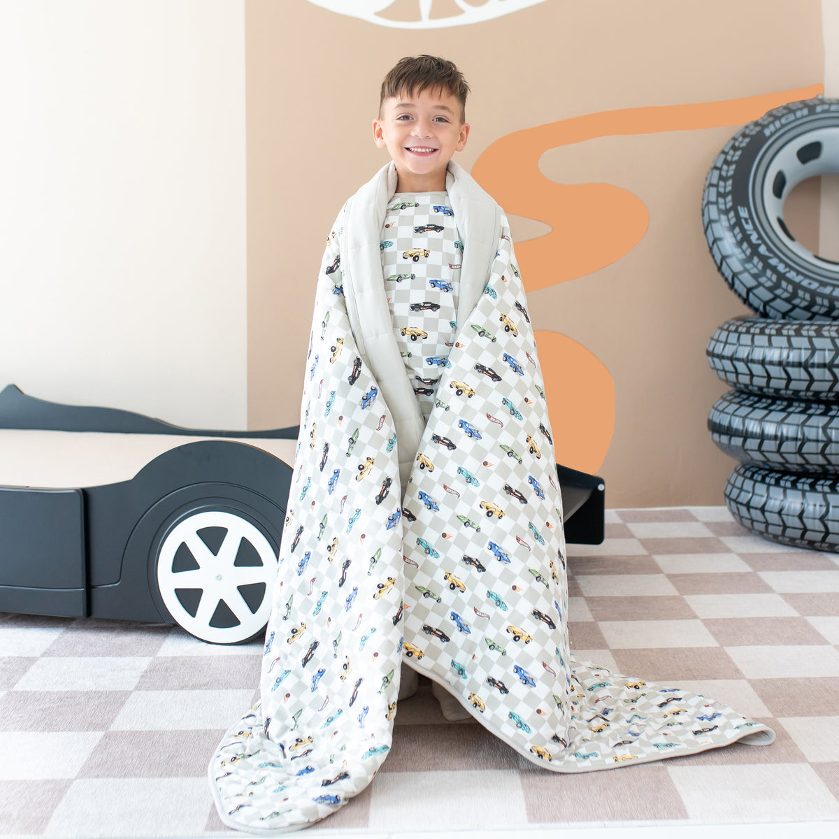Young boy standing with the Youth Blanket in Fast and Fierce wrapped around him