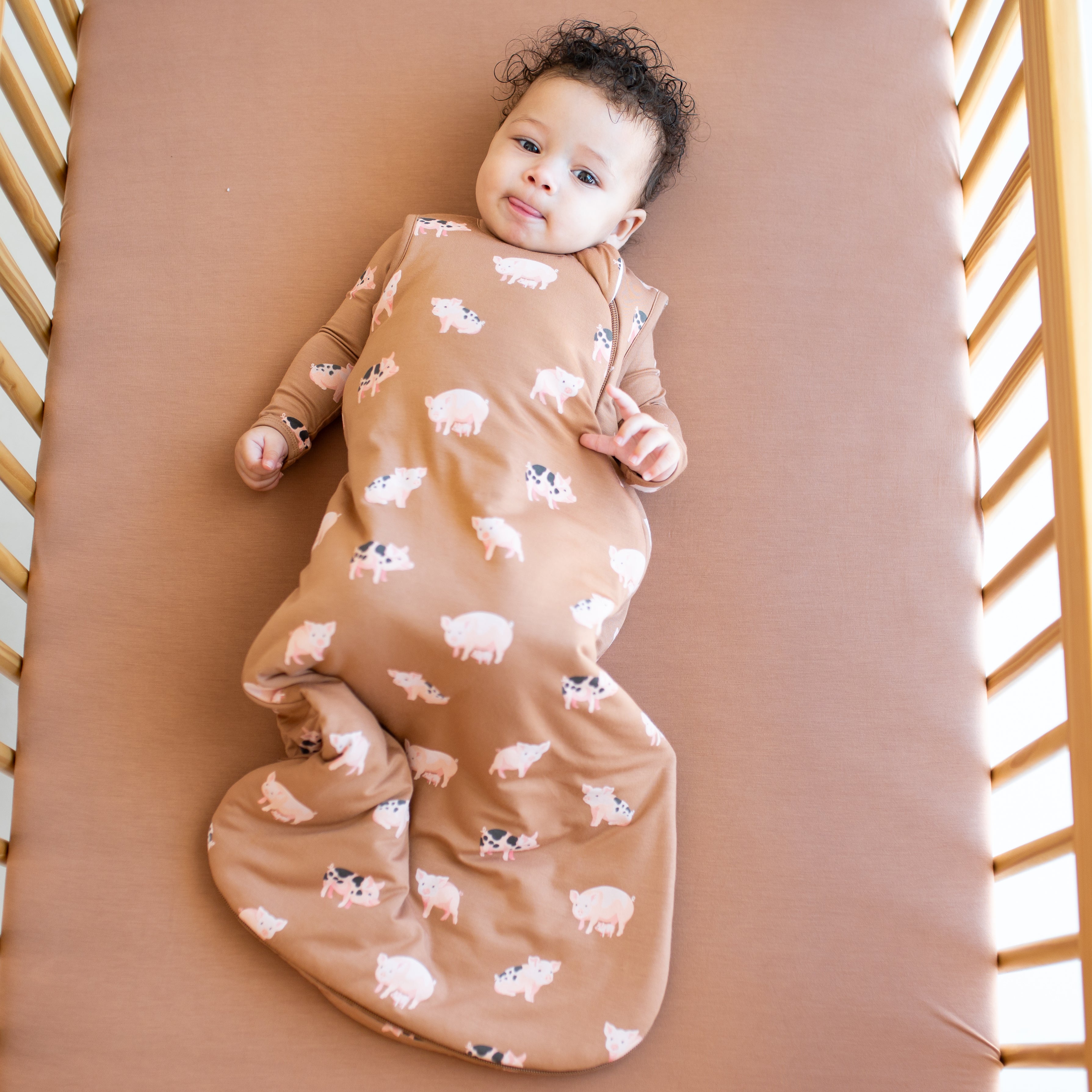 Baby wearing bamboo Sleep Bag in Pig 1.0 and matching long sleeve pajamas