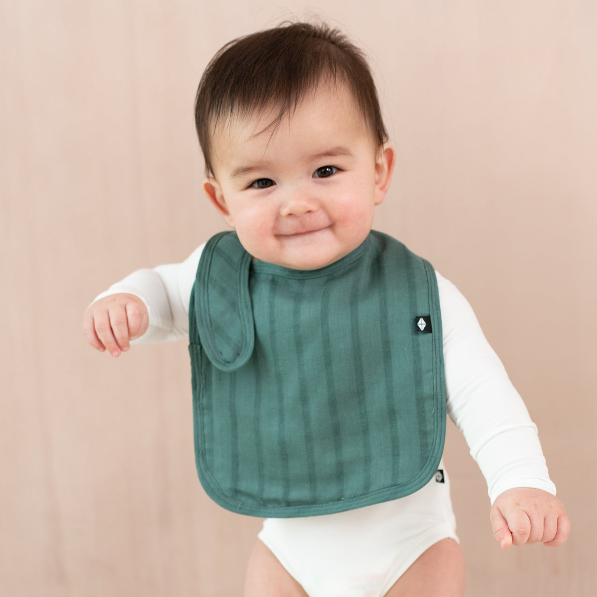 Baby wearing Bamboo Muslin Bib in Pine