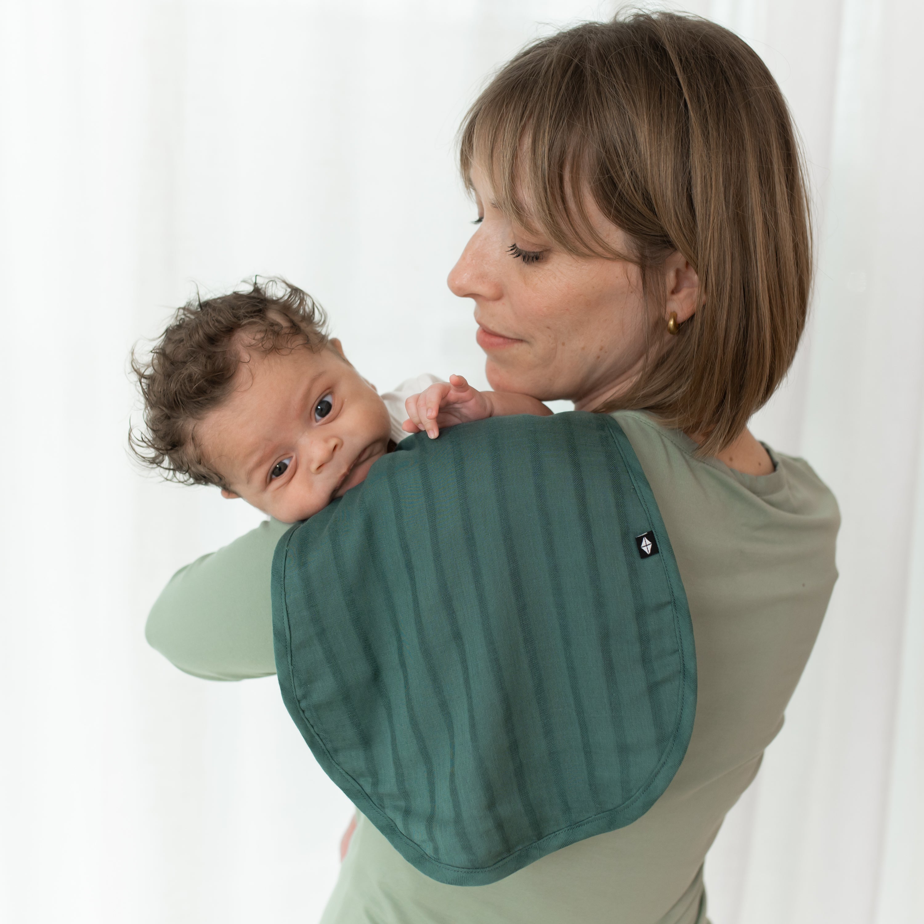 Mom holding baby with Bamboo Muslin Burp Cloth in Pine