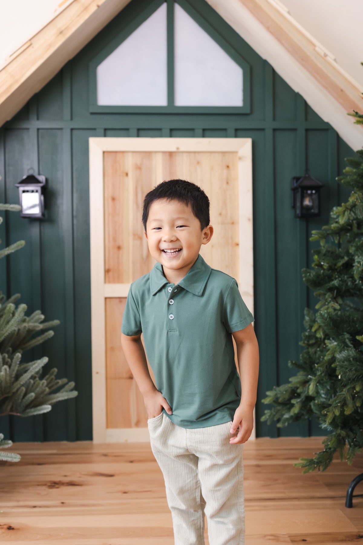 Toddler standing in front of door wearing Toddler Short Sleeve Polo in Pine over off white pants