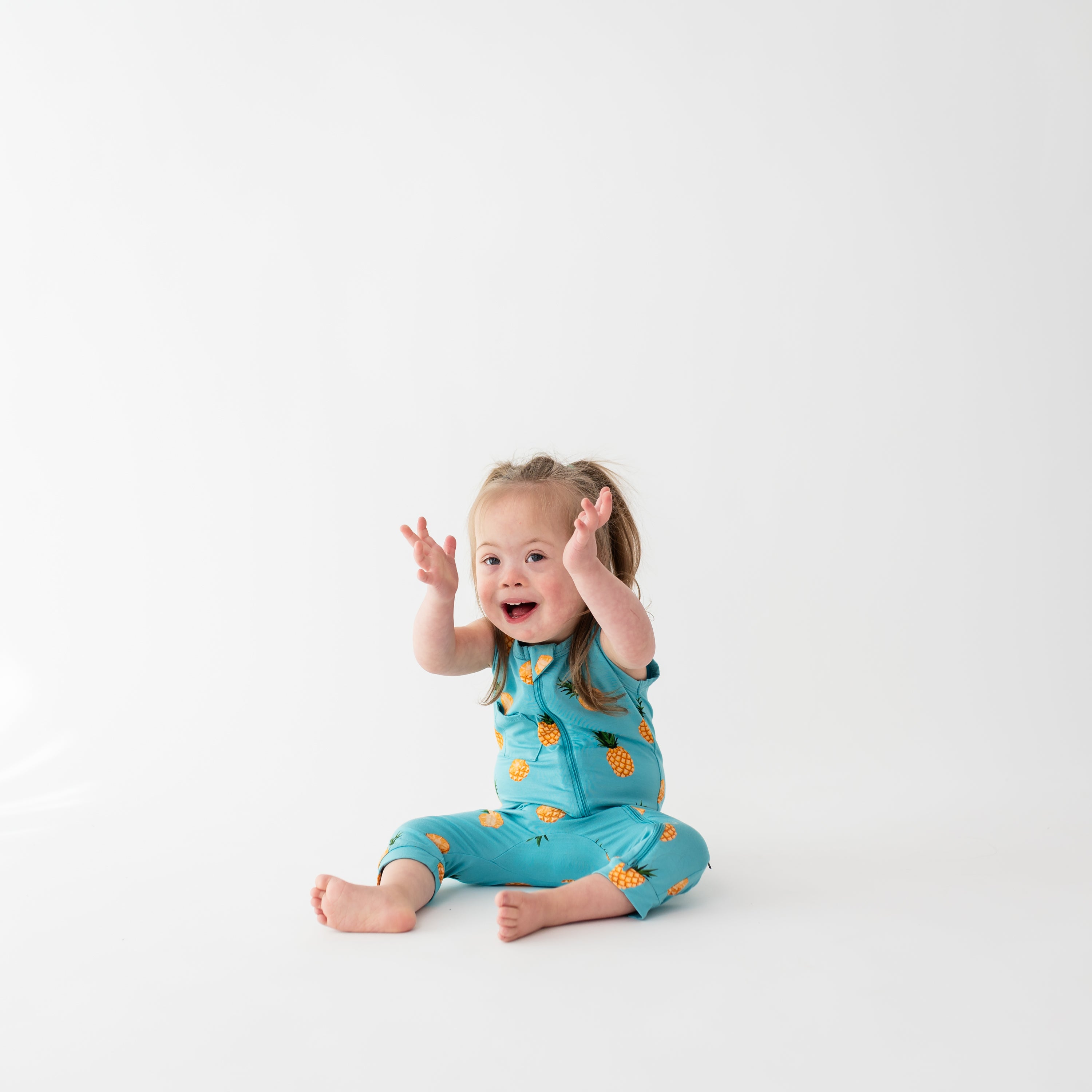 Toddler wearing Kyte Baby Sleeveless Zippered Romper with Dual Zipper in Pineapple